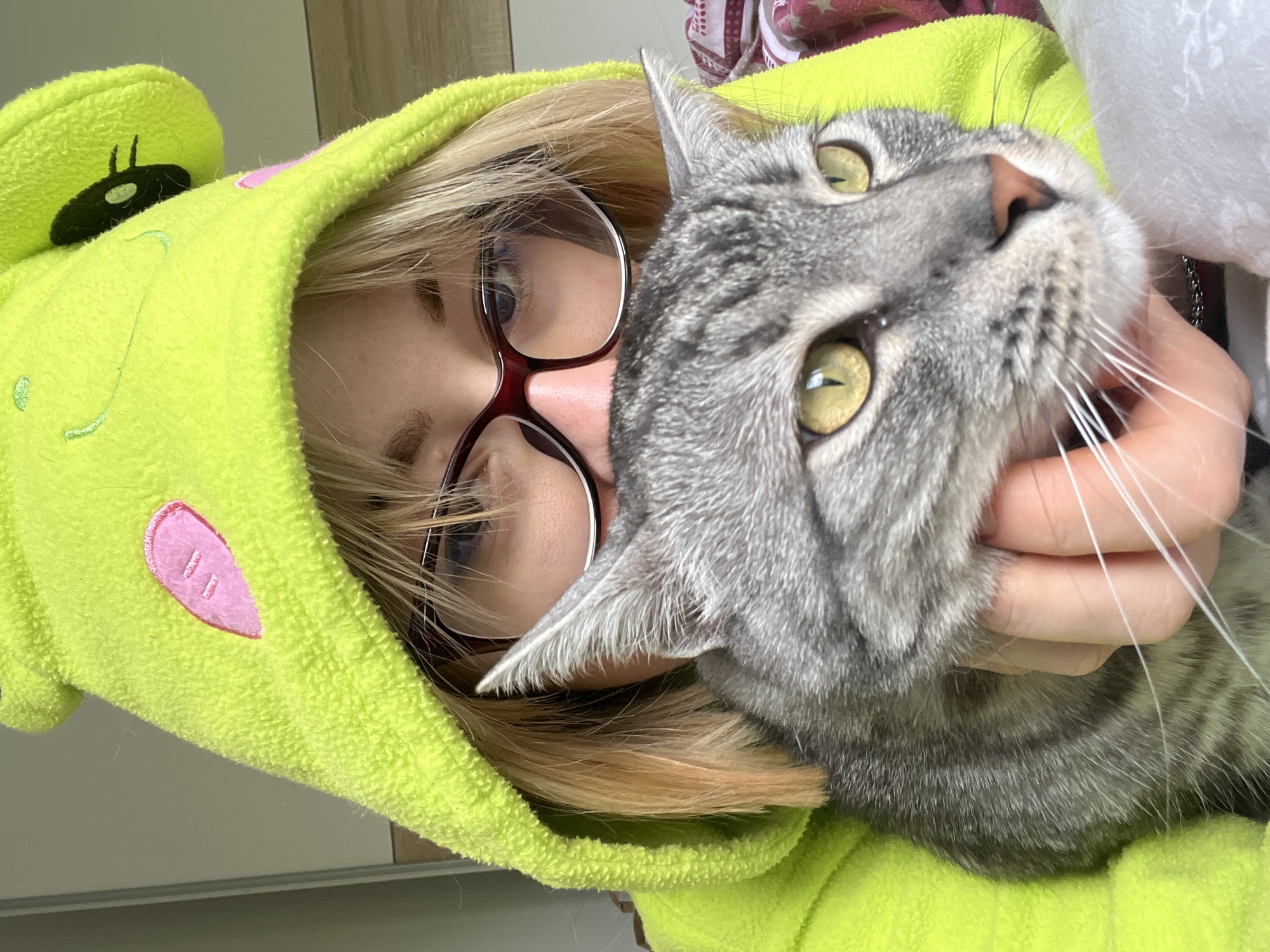 Person in frog onesie holds cat in Boreti