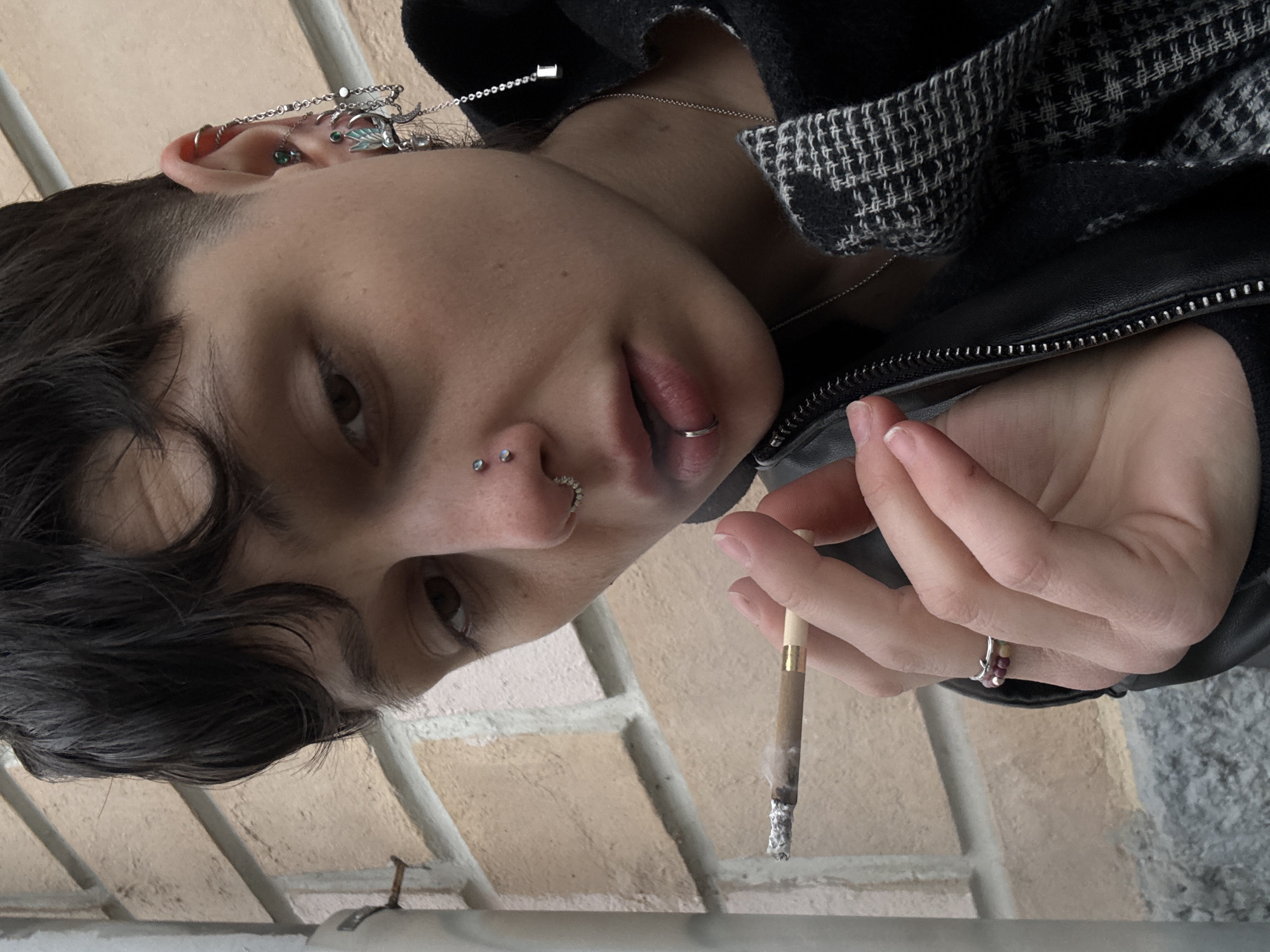 Person with facial piercings photographed smoking in Moscow