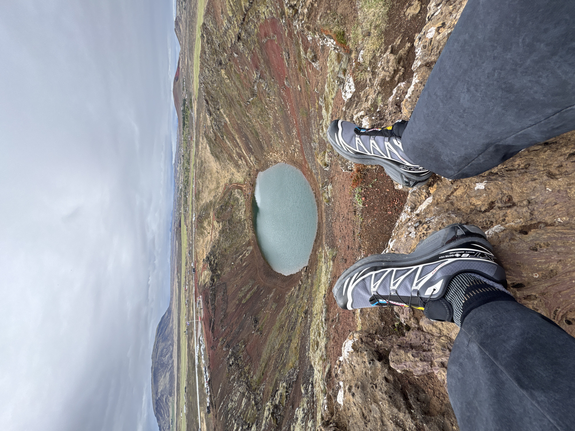 Tourist sits at edge of Iceland's Kerid volcanic crater