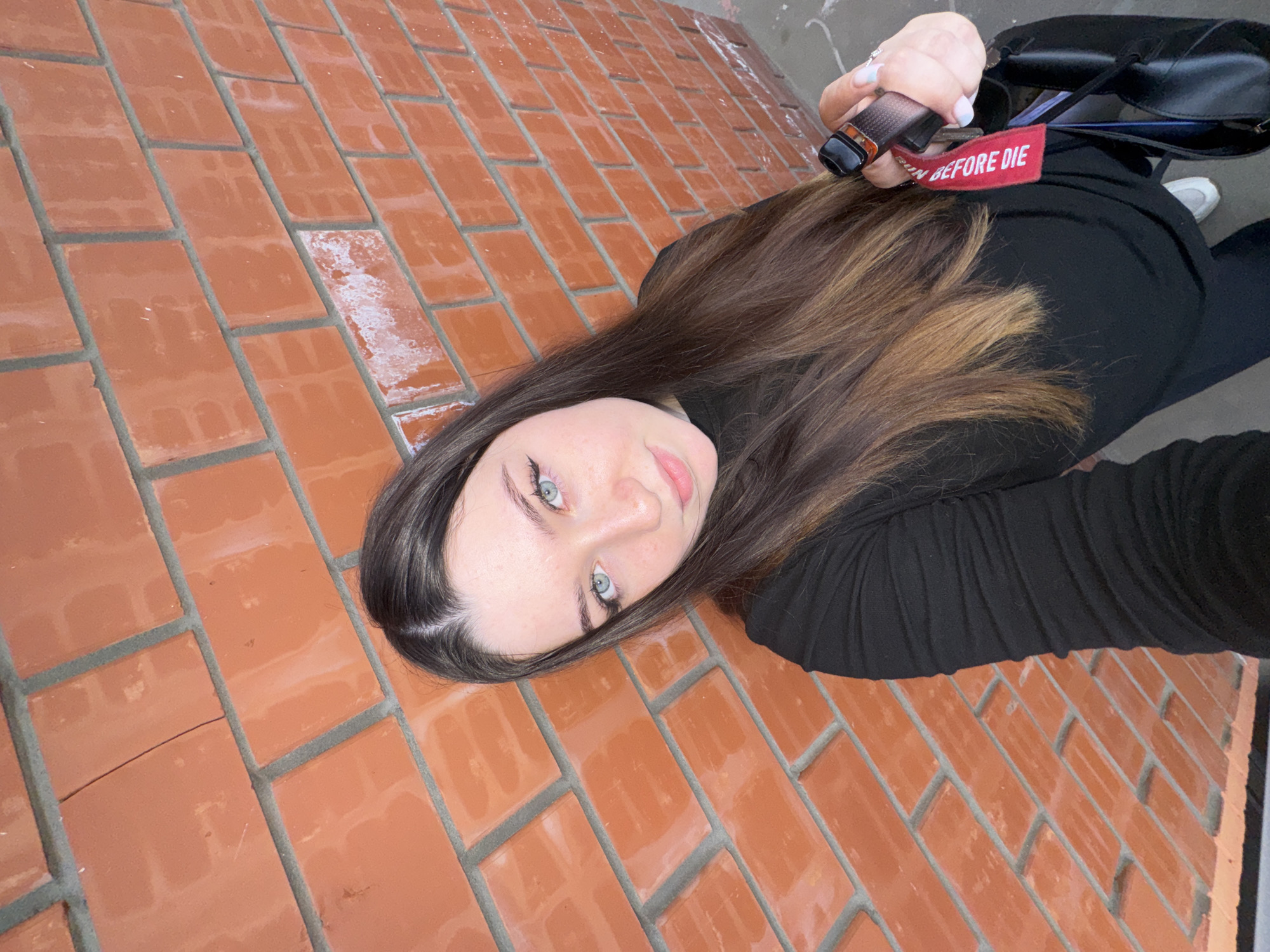 Woman takes selfies against brick wall in Perm, Russia