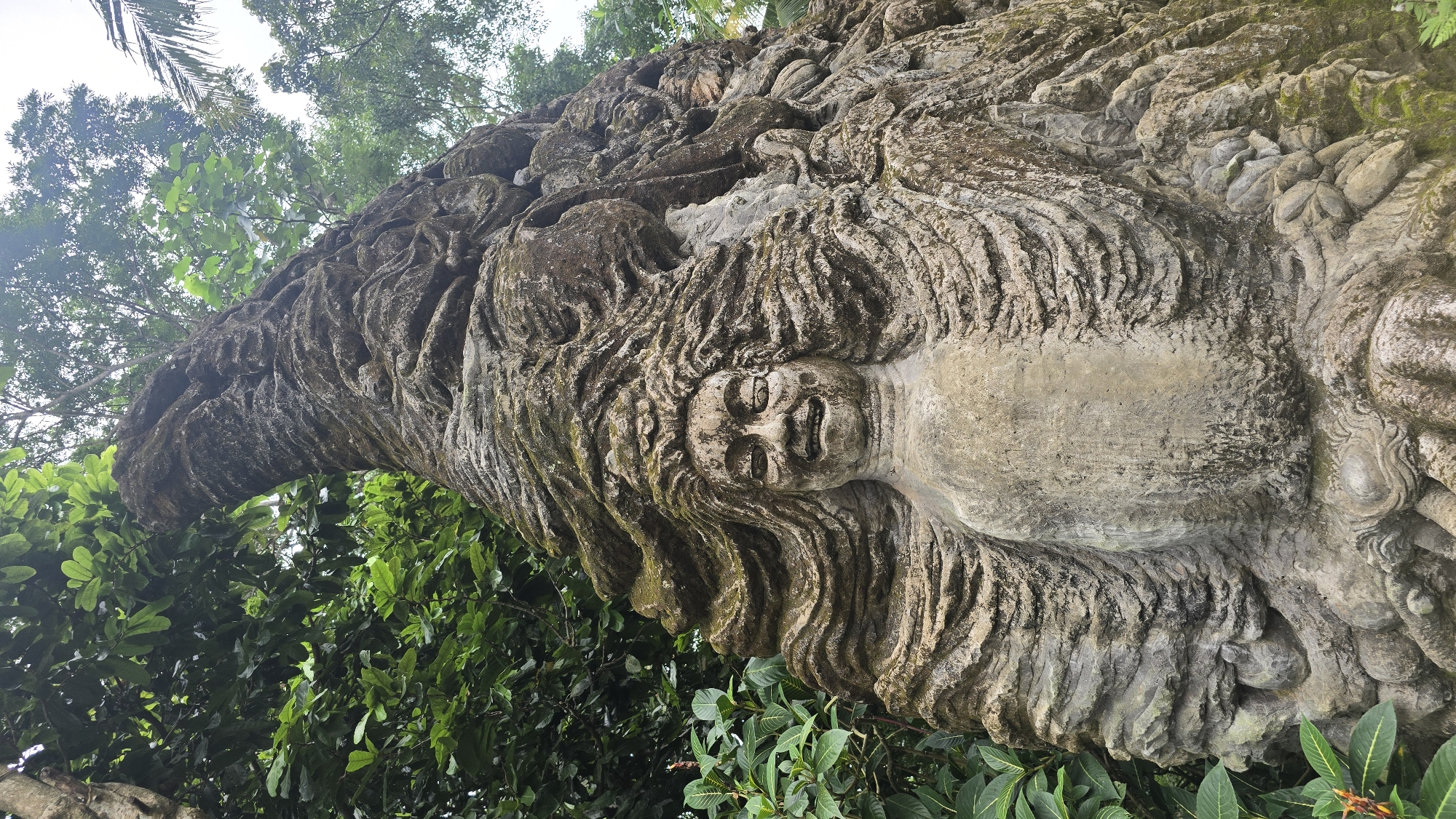 Ancient stone sculptures documented in Ubud forest setting