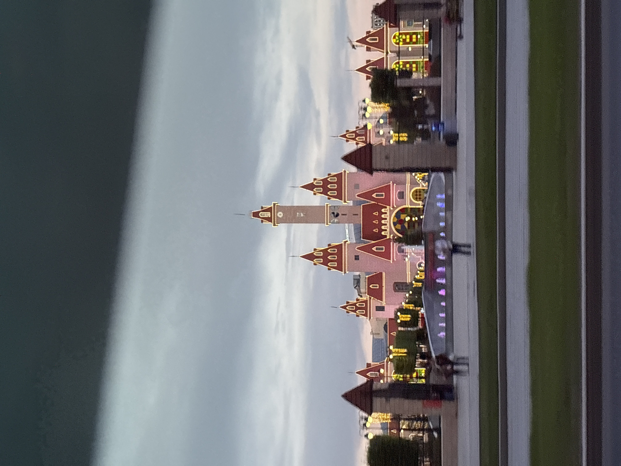 Urban evening walkthrough: streets, towers, and a lit-up theme park
