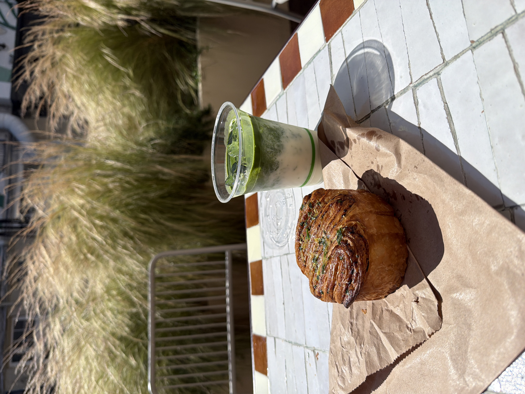 Sunny morning at a London café-bakery, green drink in hand