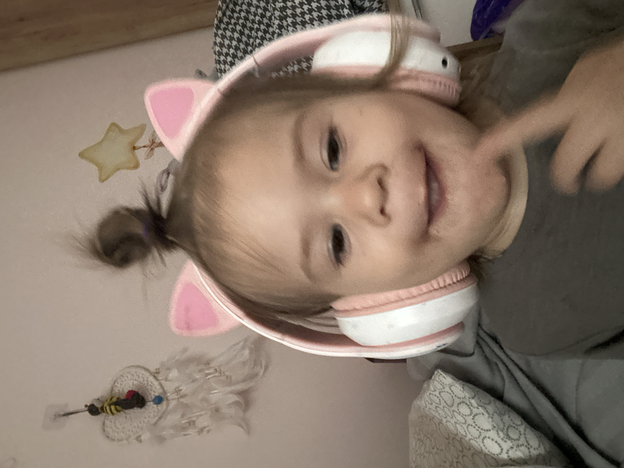 Child with cat-ear headphones spotted smiling indoors in Russia