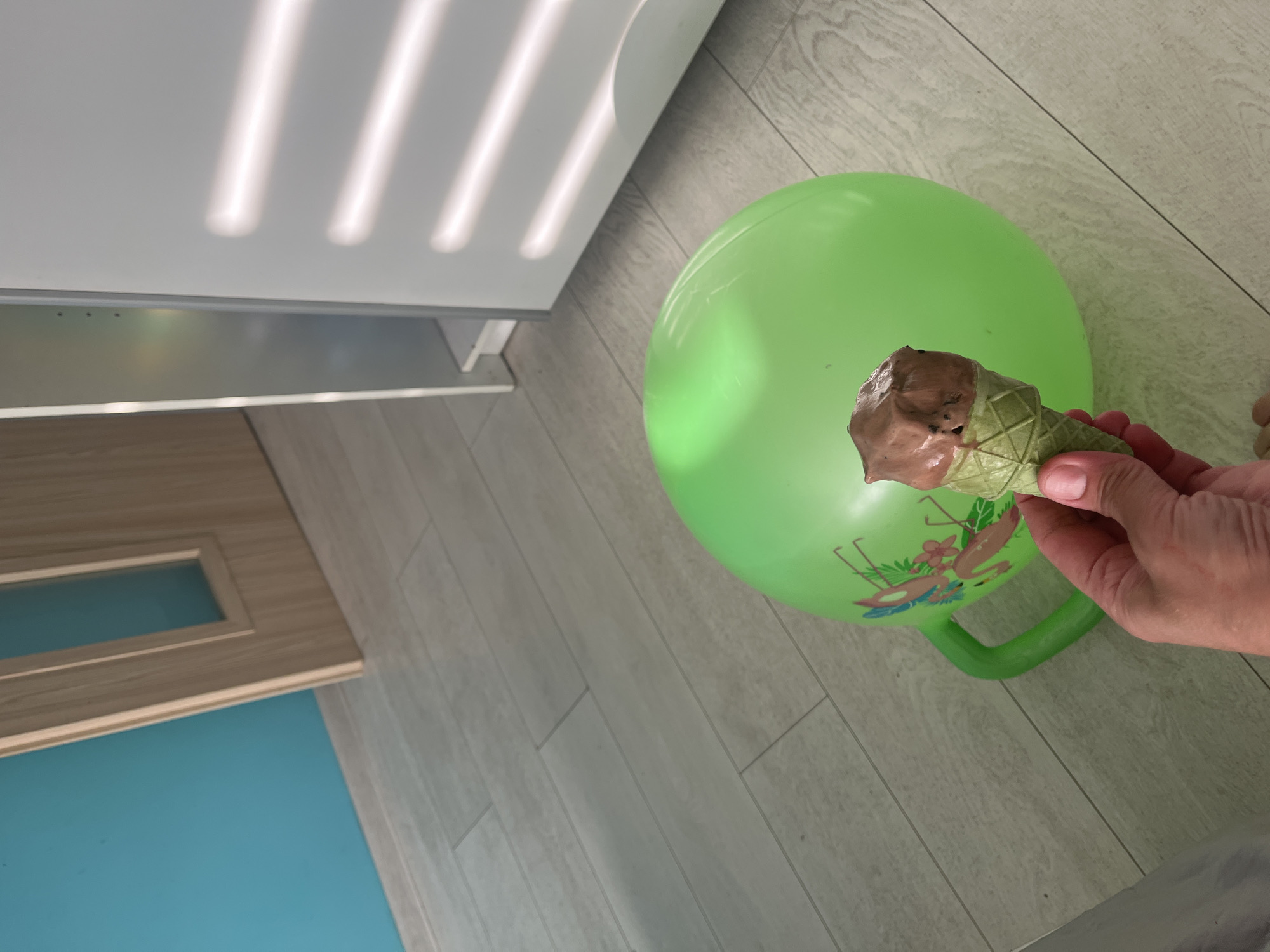 Ice cream and a flamingo hopper ball on a tiled floor