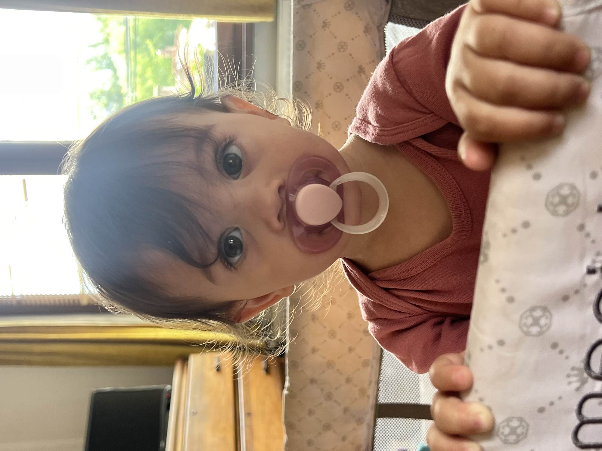 Baby with pacifier observed near window in Elena, Bulgaria