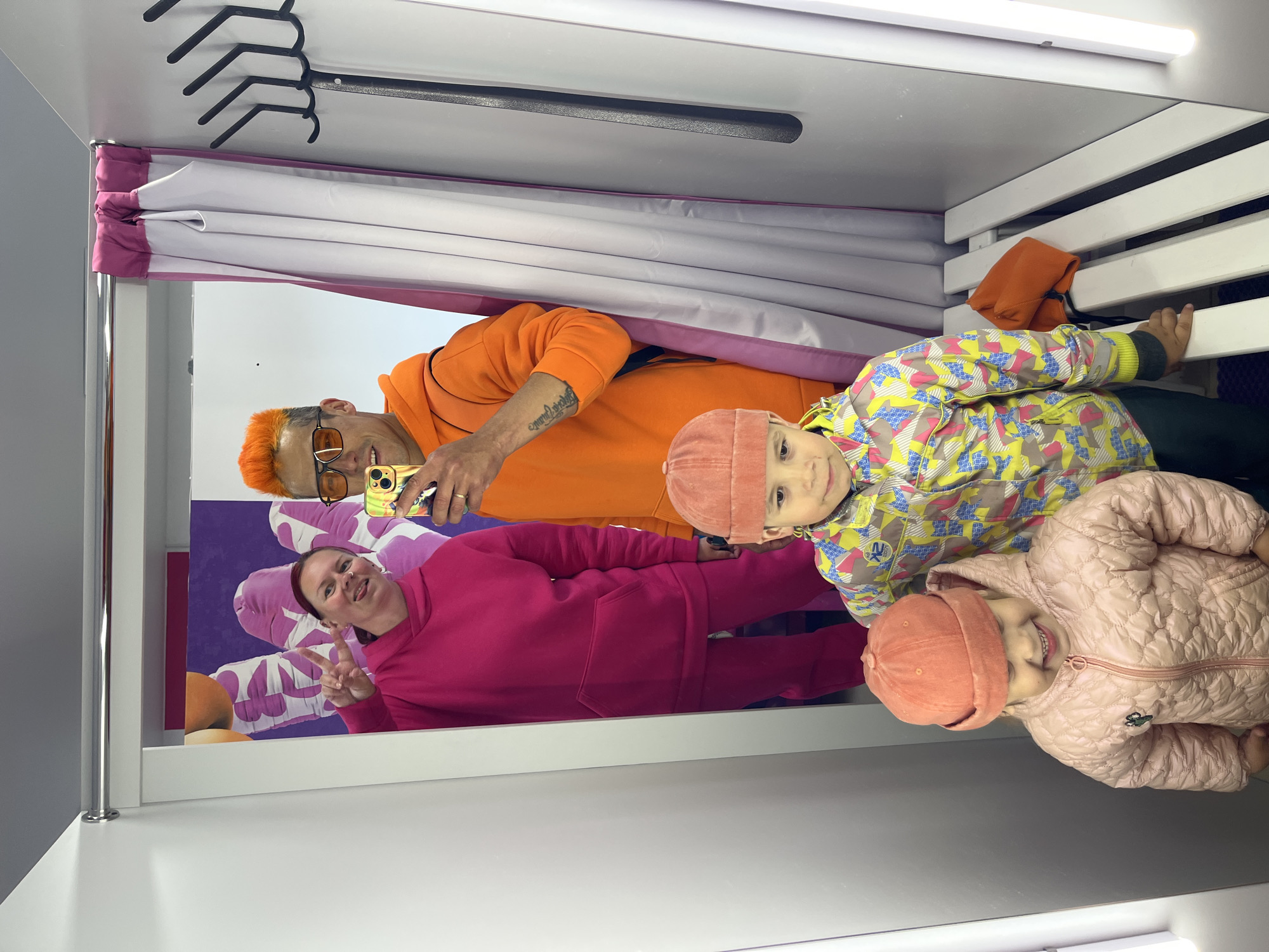 Orange-clad person shops, poses with child in Chaikovsky