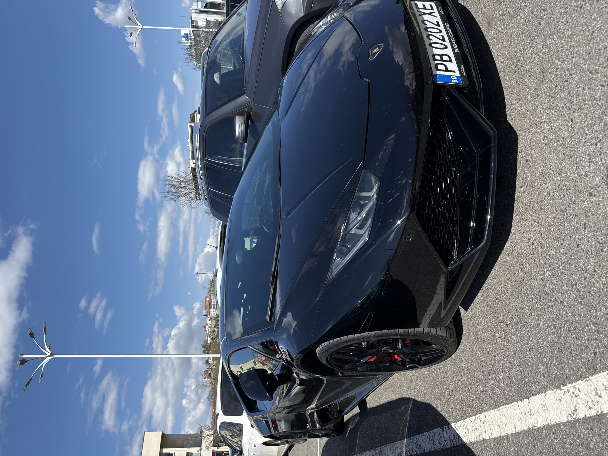Man poses with luxury cars in Plovdiv parking lot