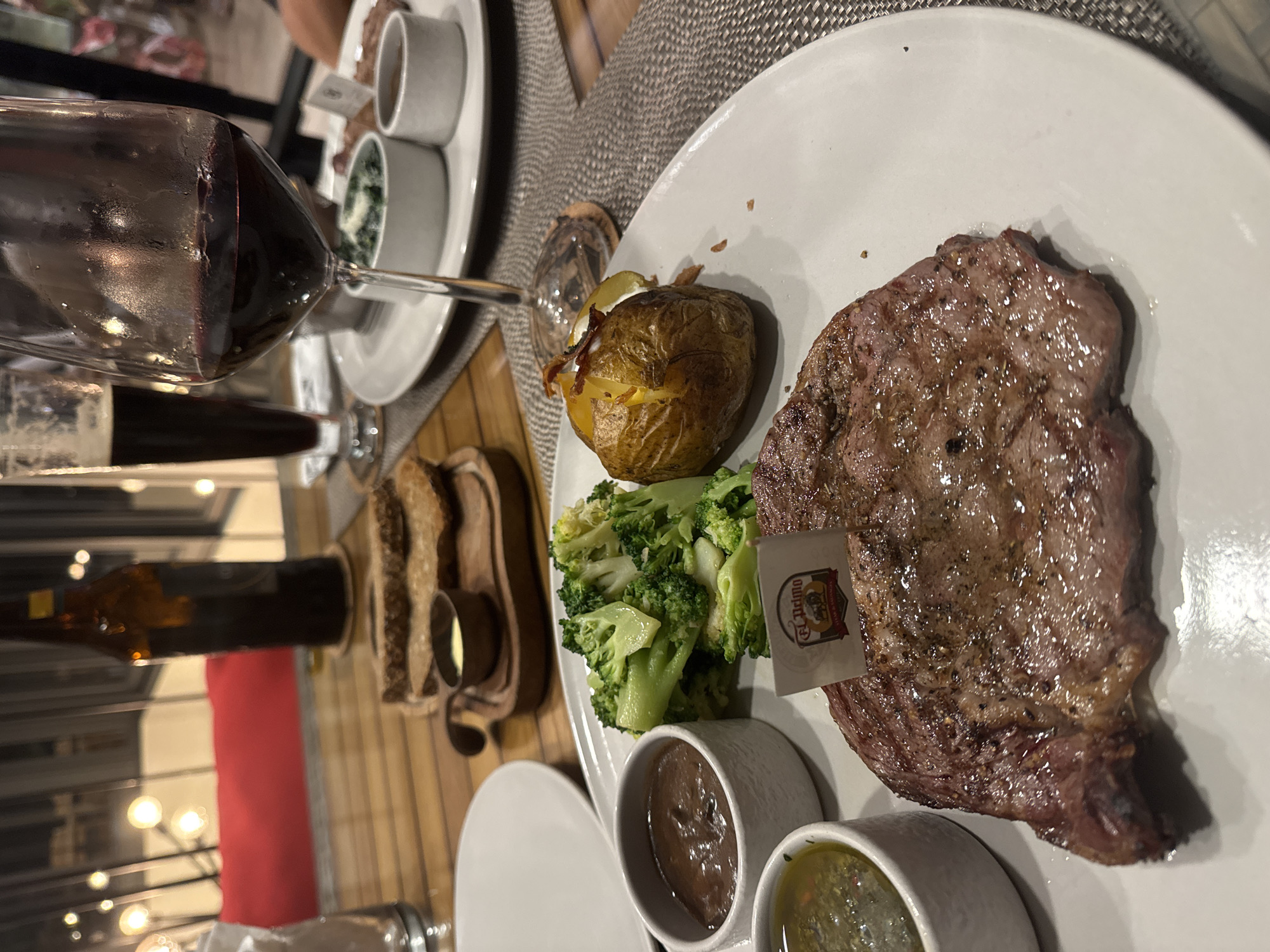 Restaurant dinner documented with steak, sides, and wine
