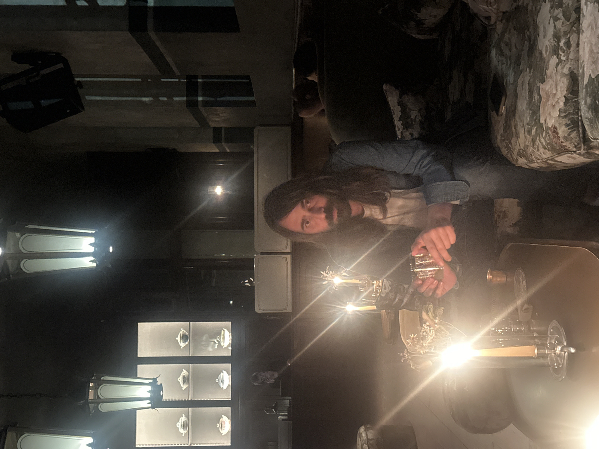 Man enjoys drink at illuminated Milan bar