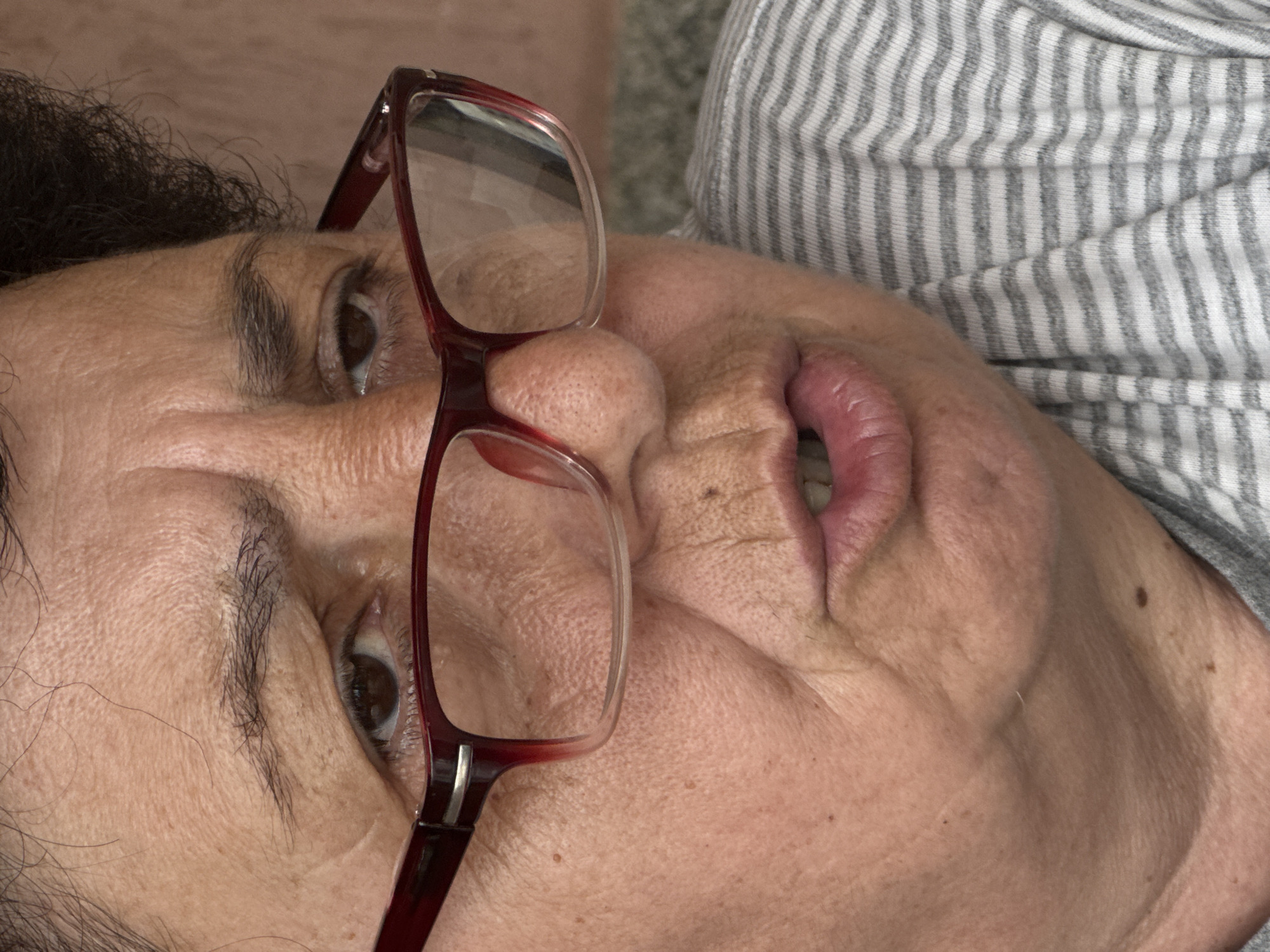 Elderly woman with red glasses uses smartphone in Bulgaria