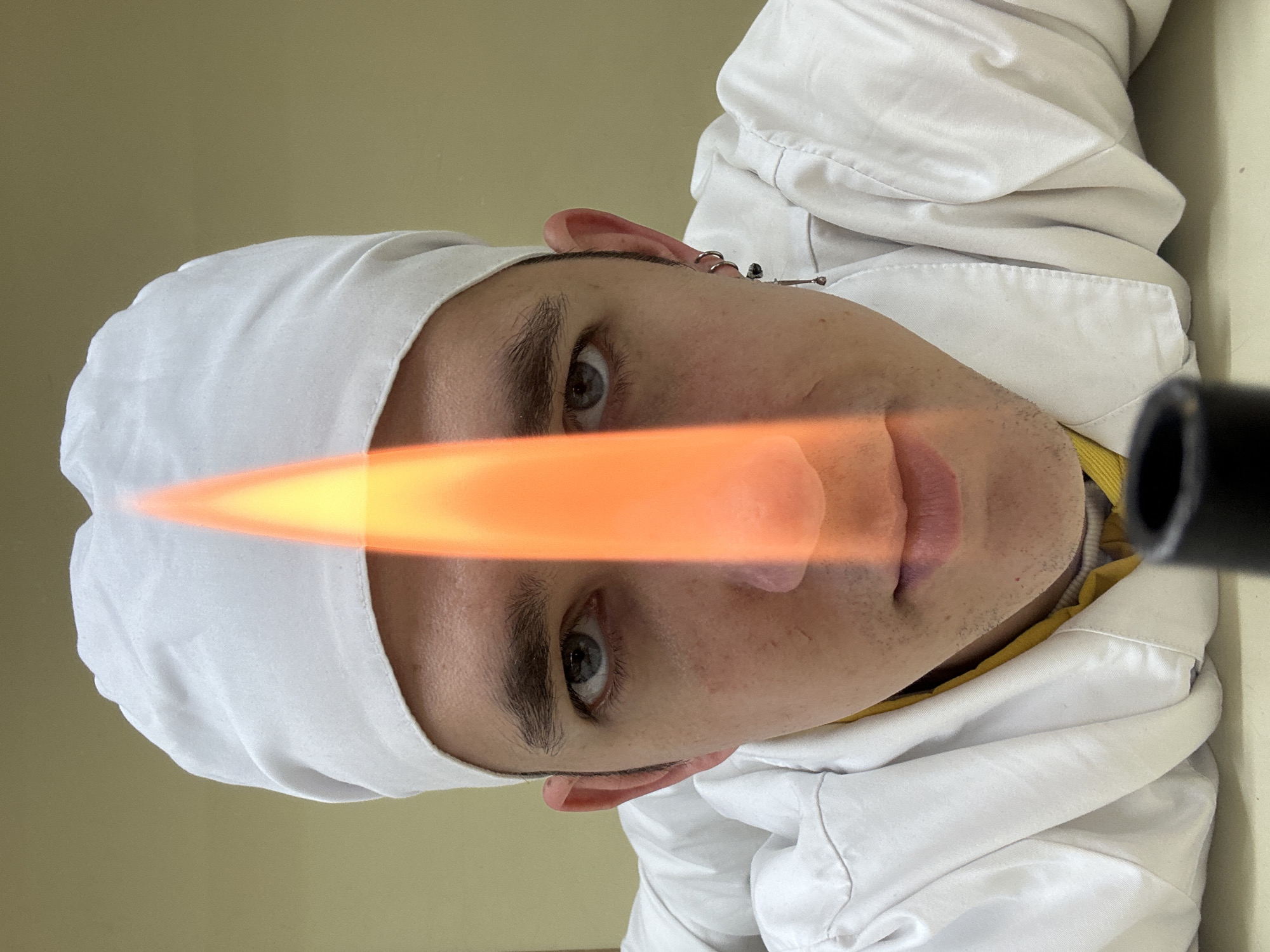 Person in white uniform holds lit torch in Saratov