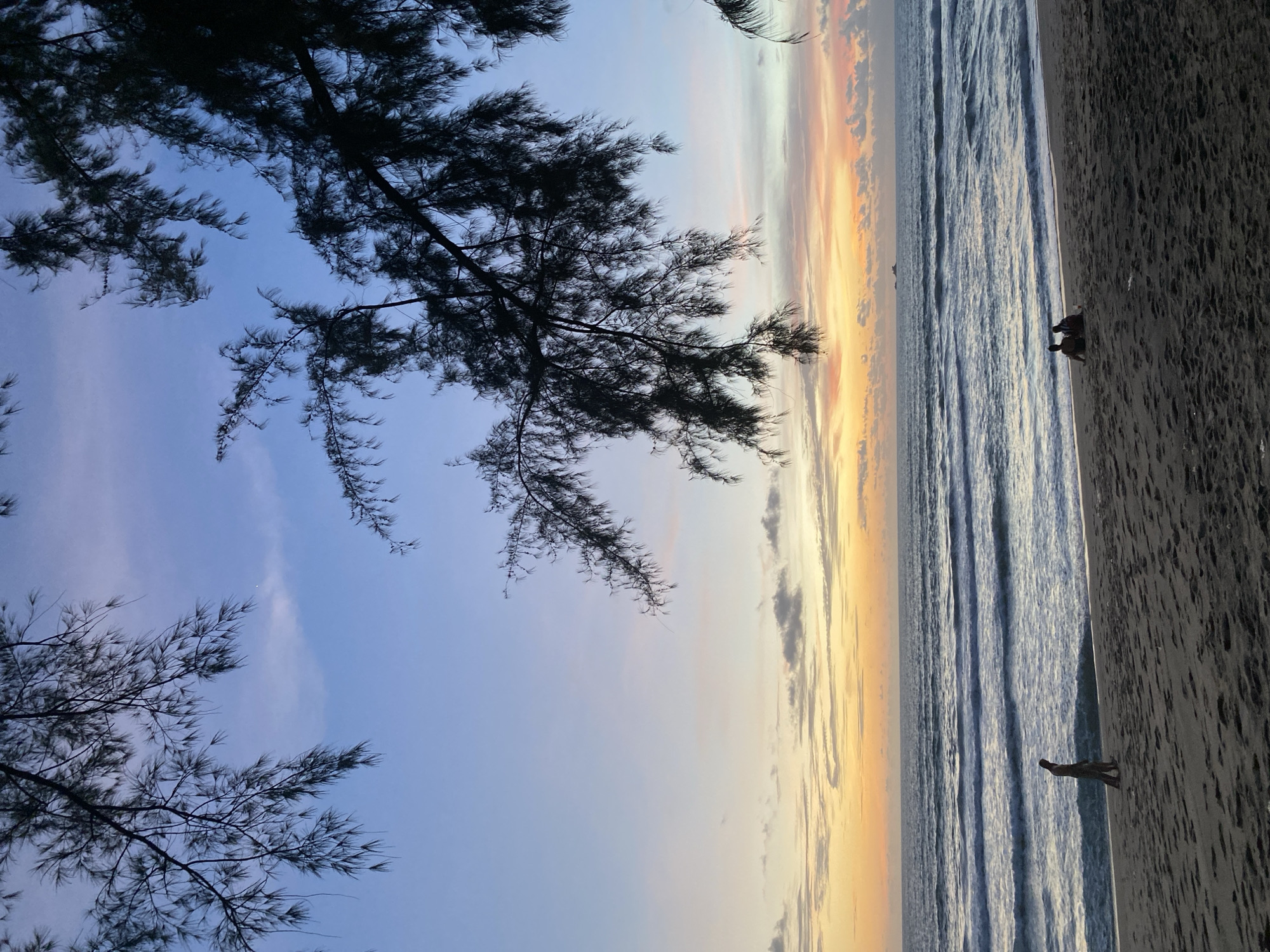 Golden hour on a Choeng Thale beach, phones in hand