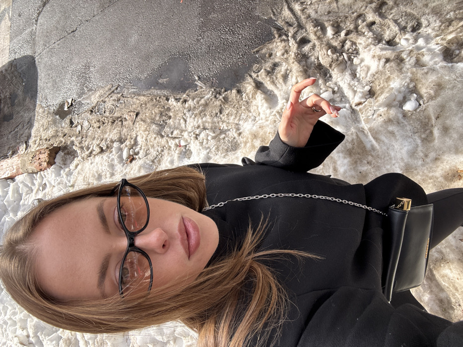 Person photographed in urban winter scene with melting snow