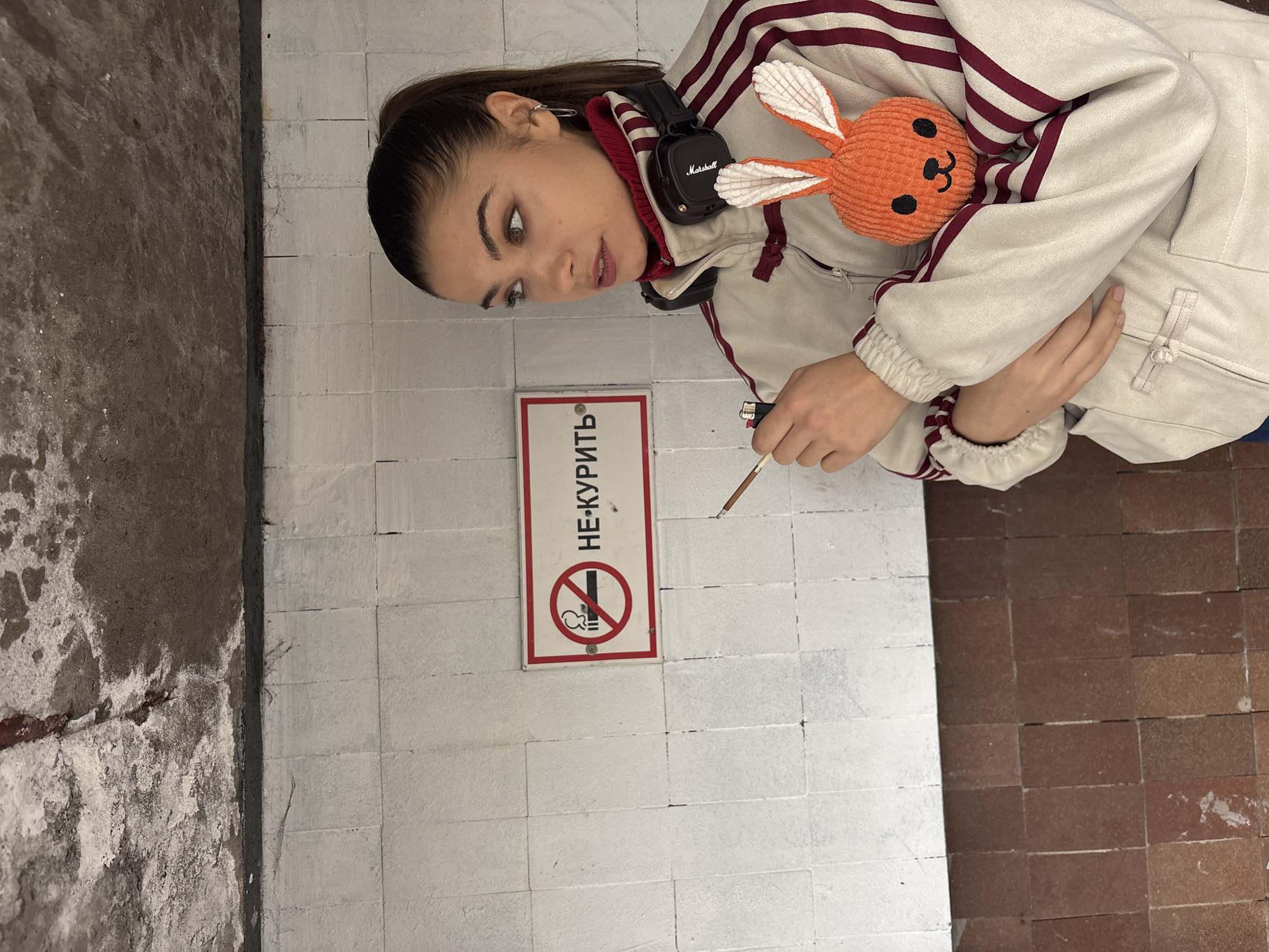 Woman smokes beside no-smoking sign in Moscow