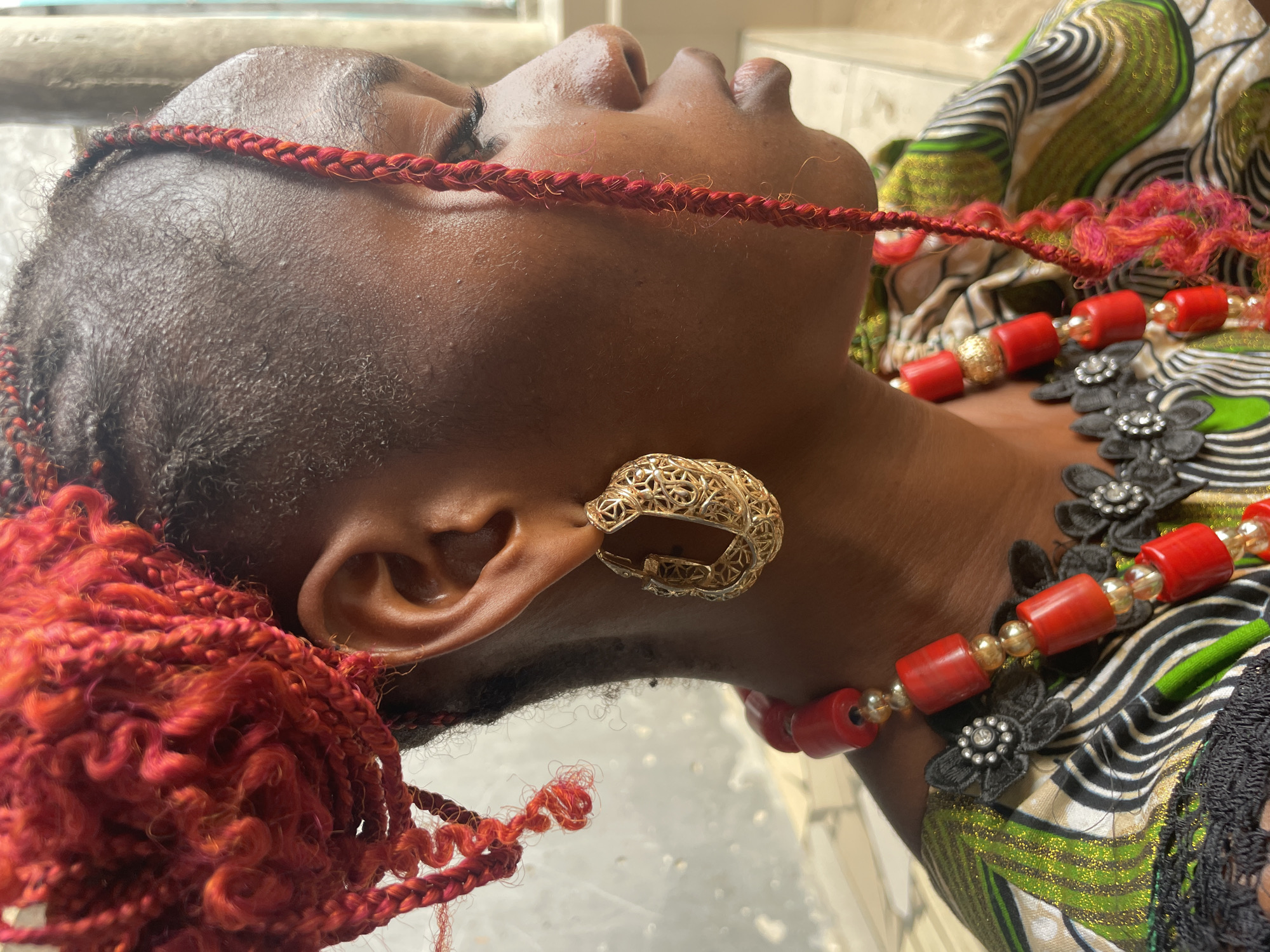 Person with red braided hair photographed in Badagry, Nigeria