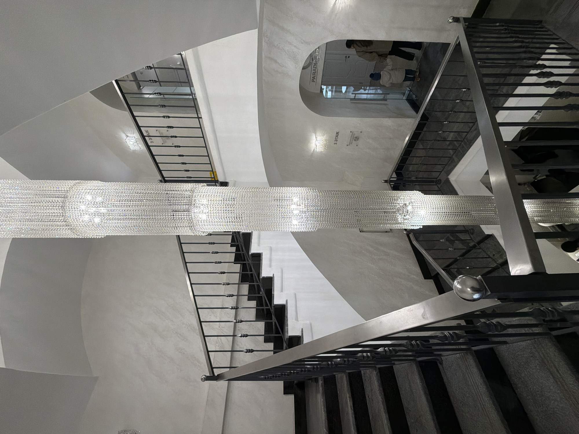 Large crystal chandelier documented in Moscow multi-story staircase interior