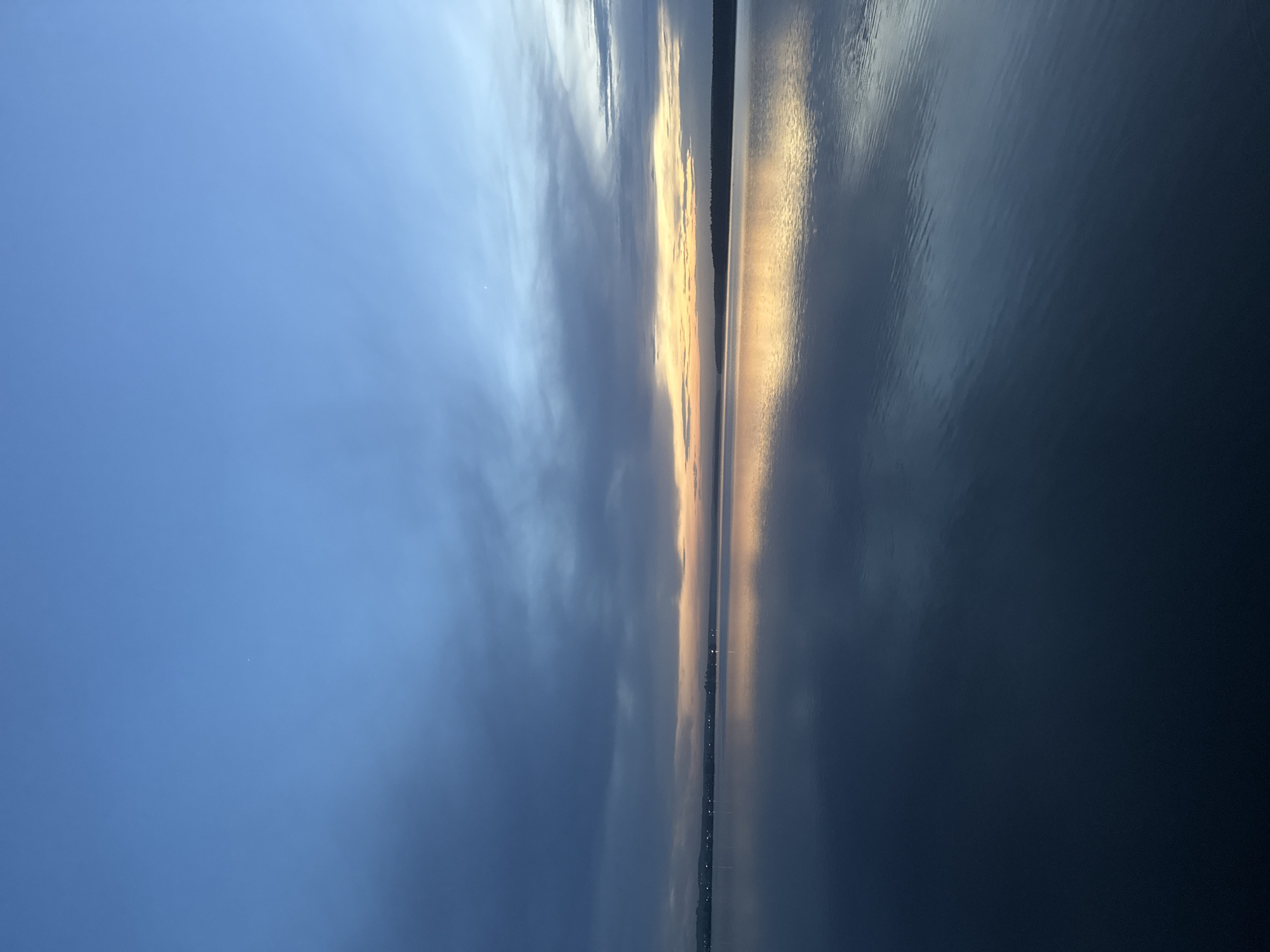 Sunset reflection captured over Votkinsk waters amid mixed clouds