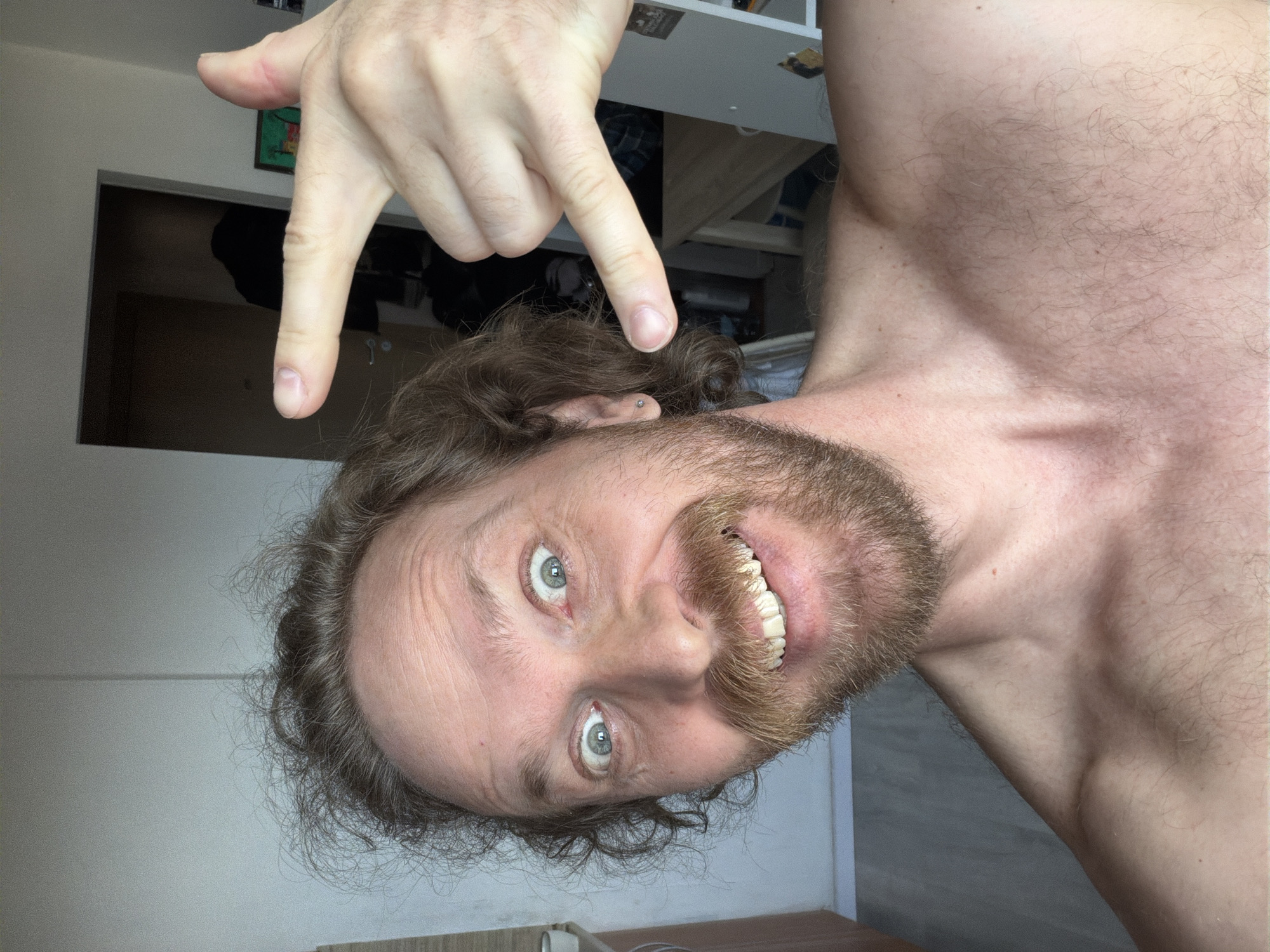 Shirtless man photographed gesturing and smiling in Saint Petersburg