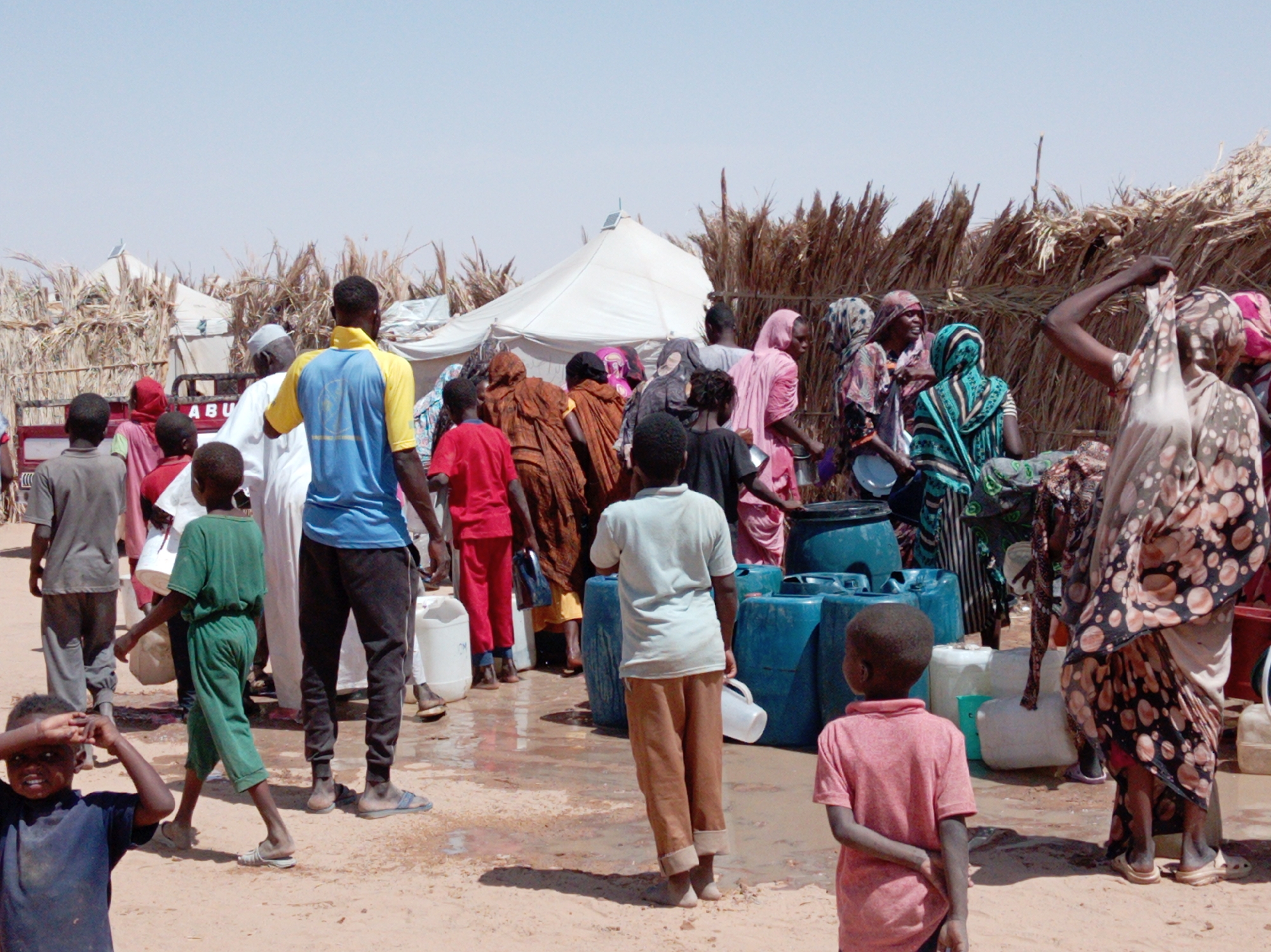 Residents gather at water distribution point in Goshabi, Sudan