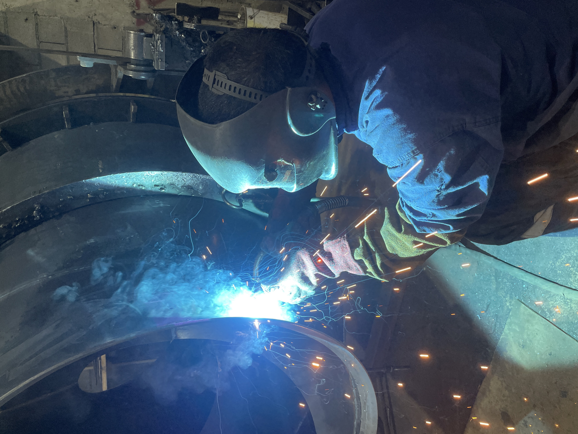Welder works on large metal structure in Montenegro factory
