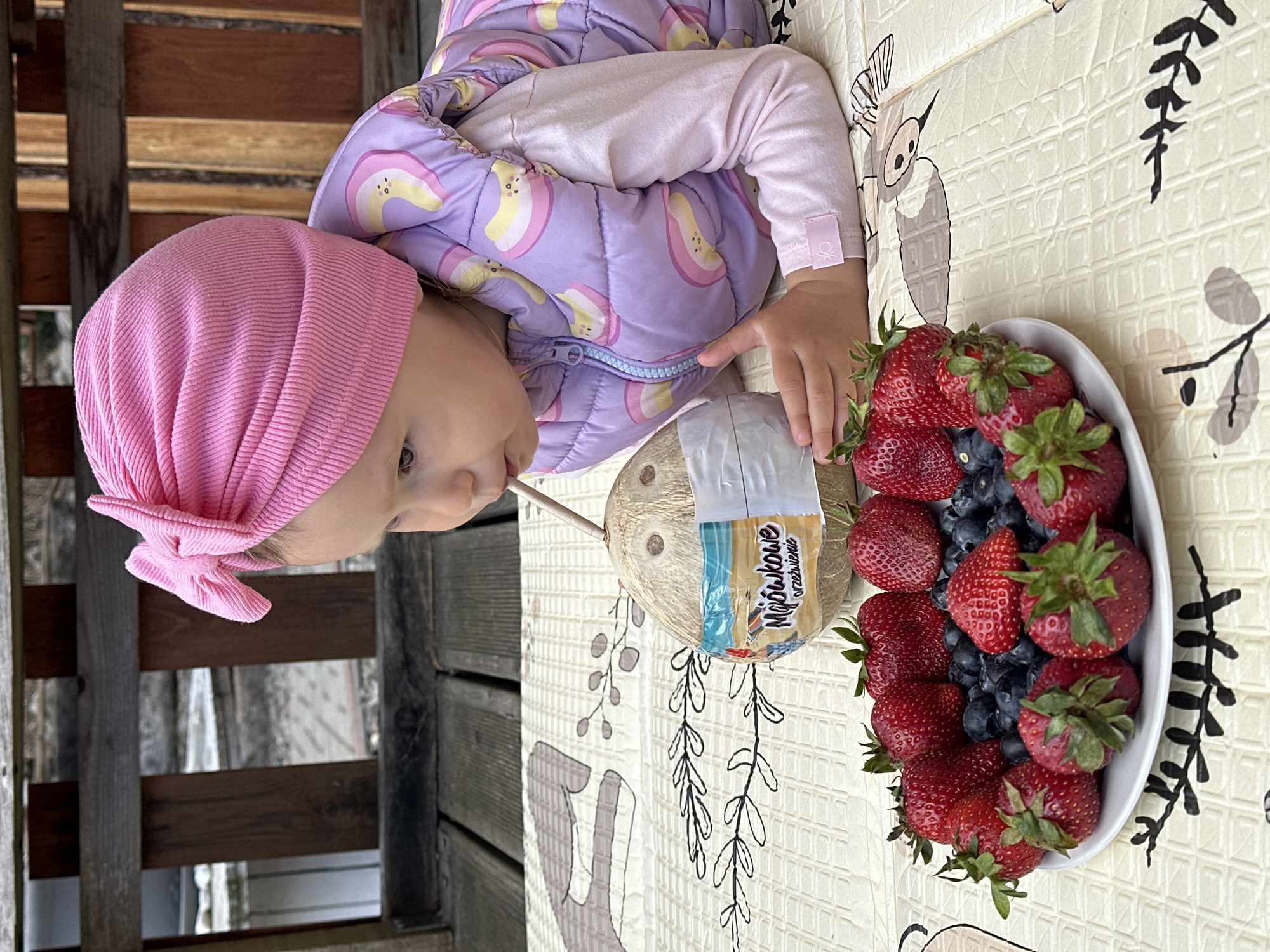 Toddler enjoys outdoor snack time on deck in Wisła