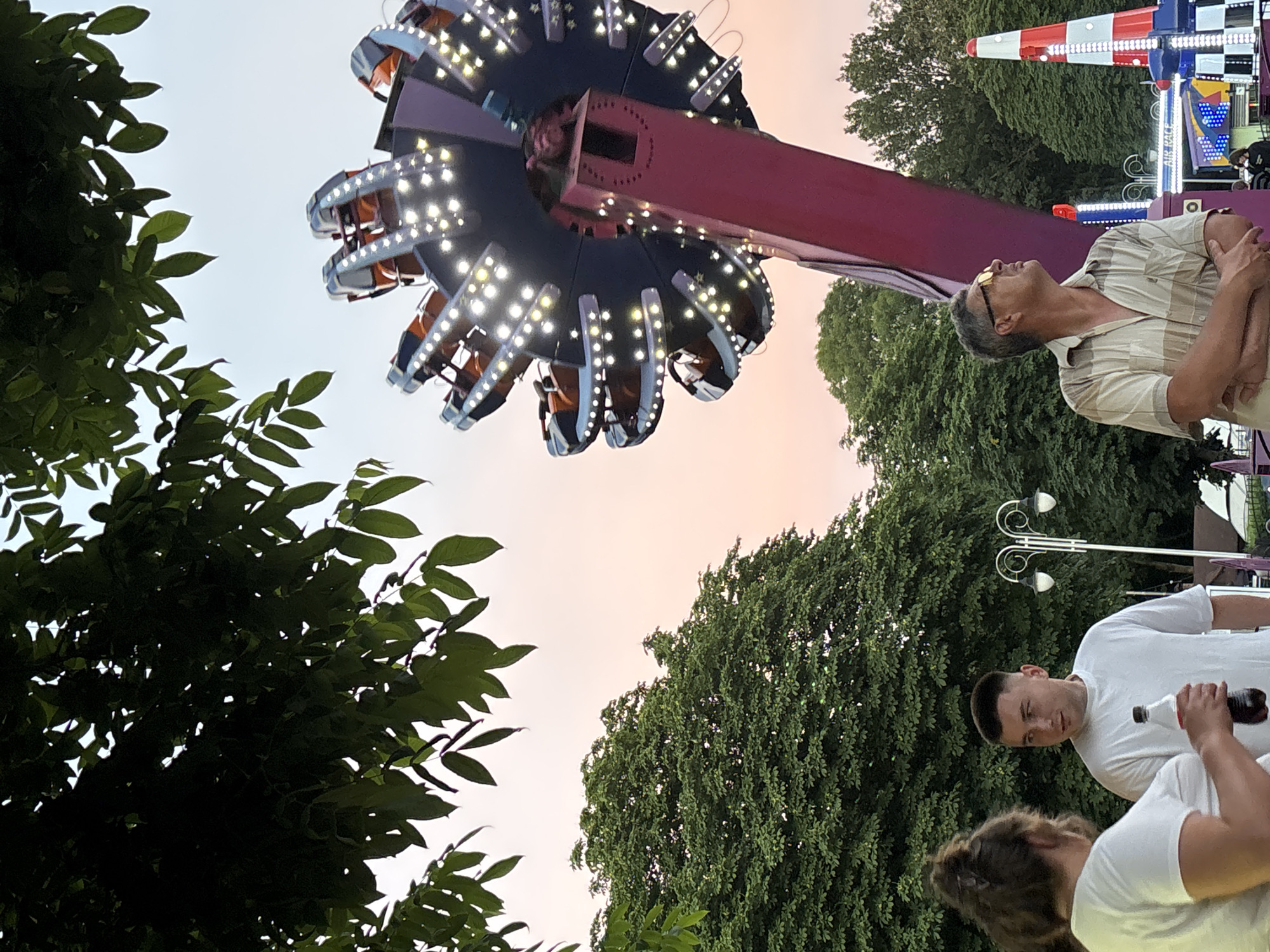 Ferris wheel glows at dusk in Homyel amusement park