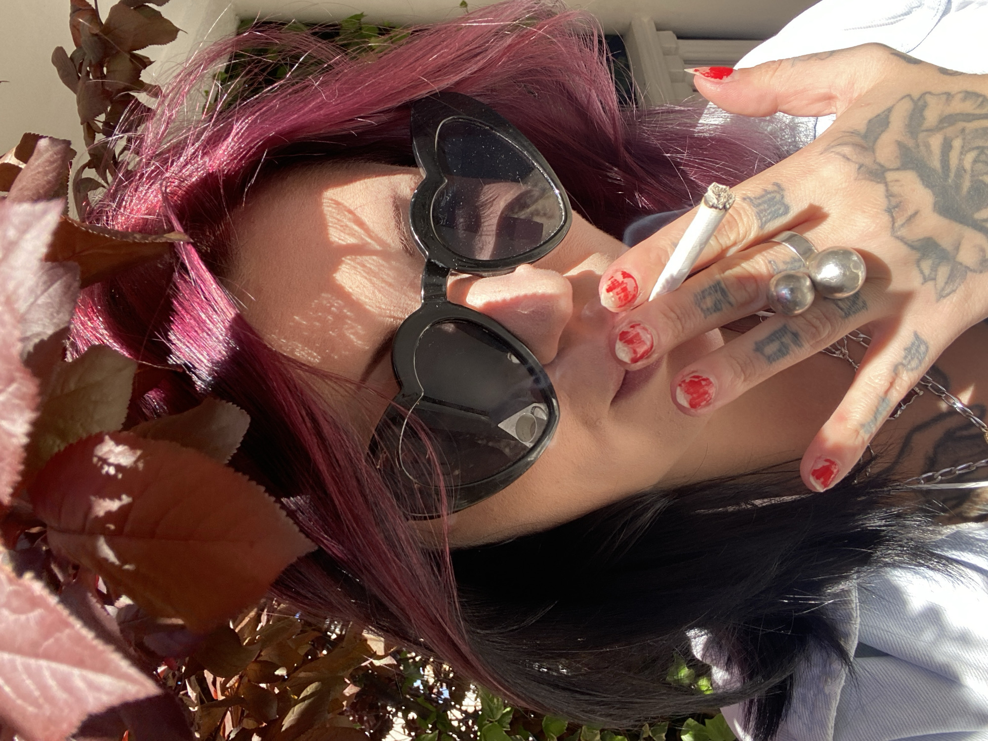 Person with magenta hair enjoys coffee outdoors in Montenegro