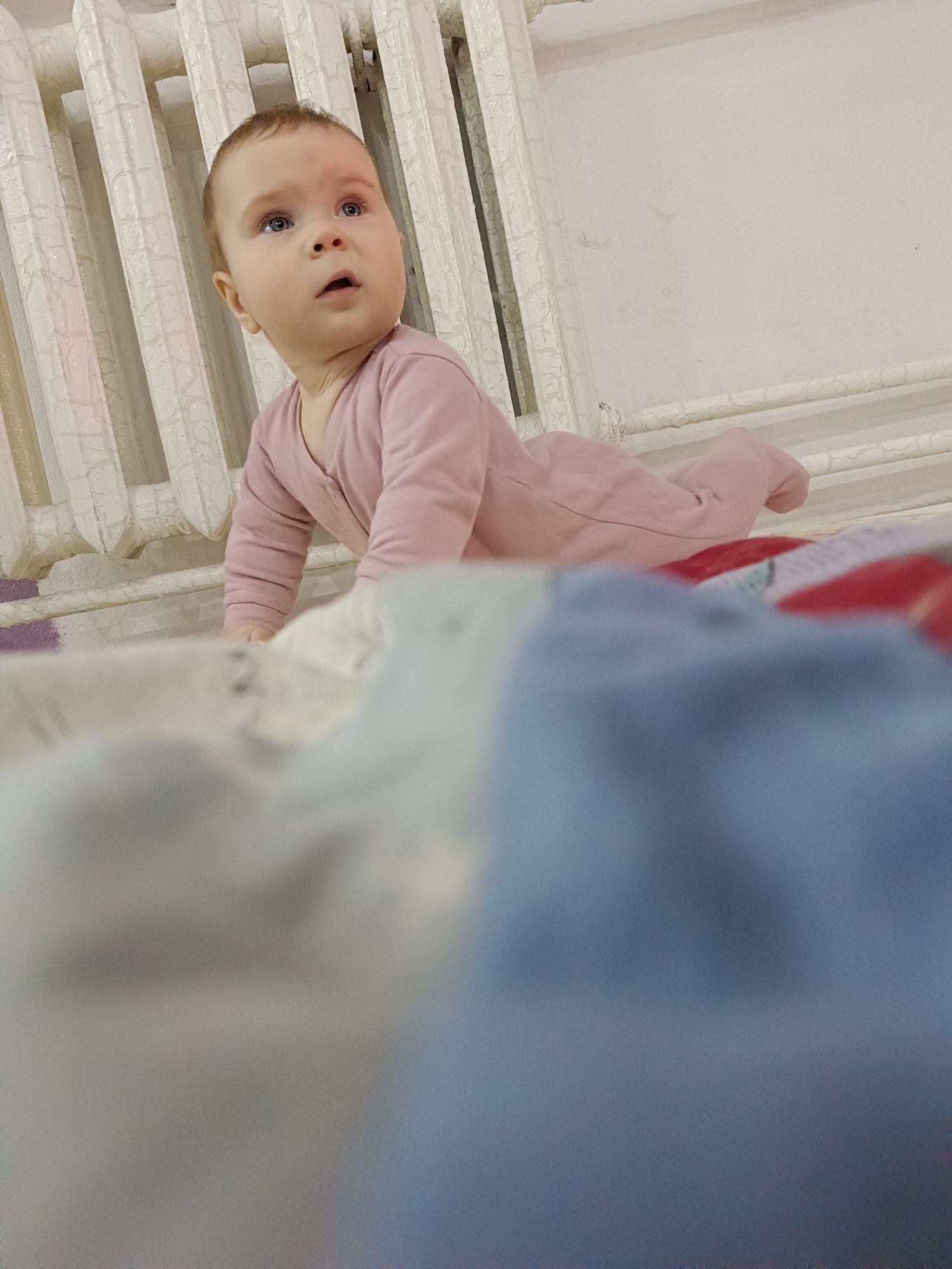Baby crawls on bed in Russian home
