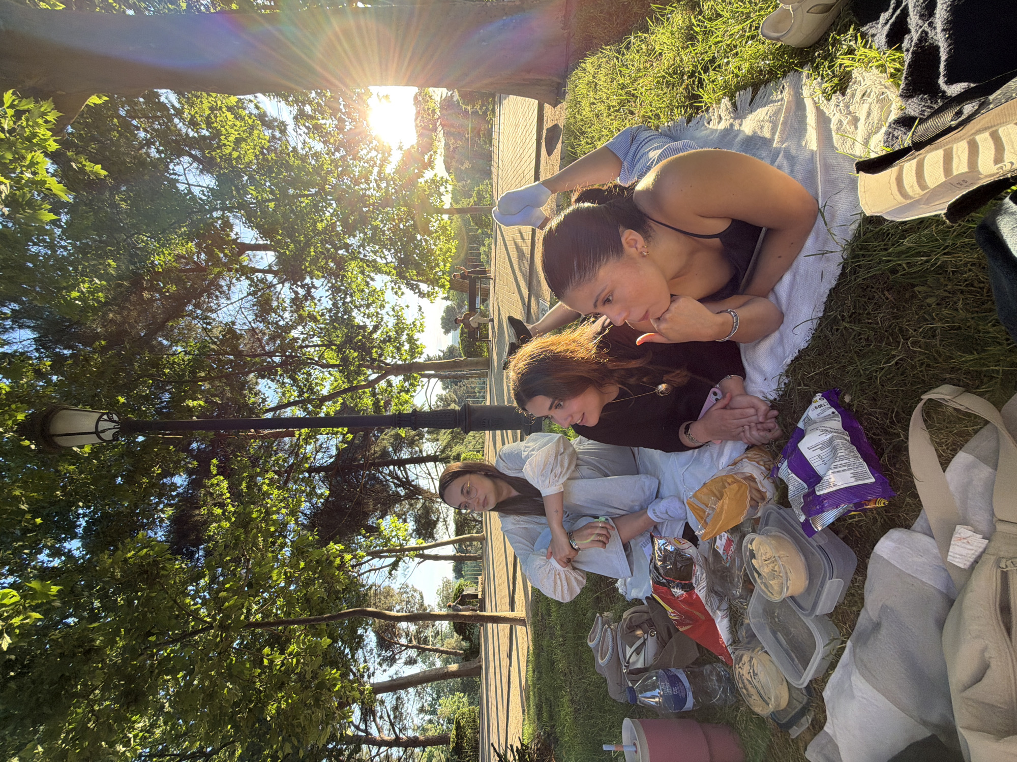 Three women enjoy afternoon picnic in Madrid park