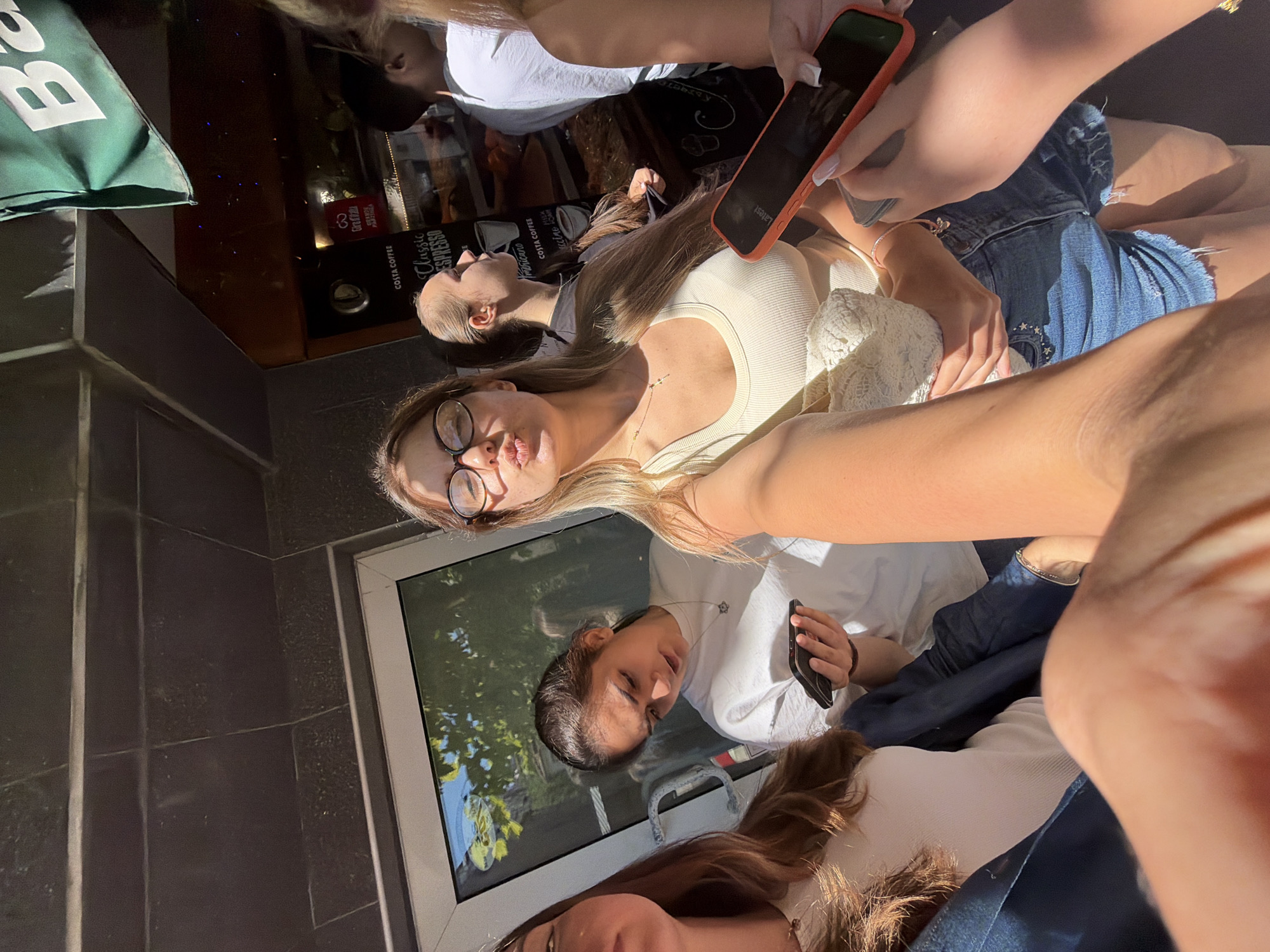 Young women take selfies outside Burgas shops morning