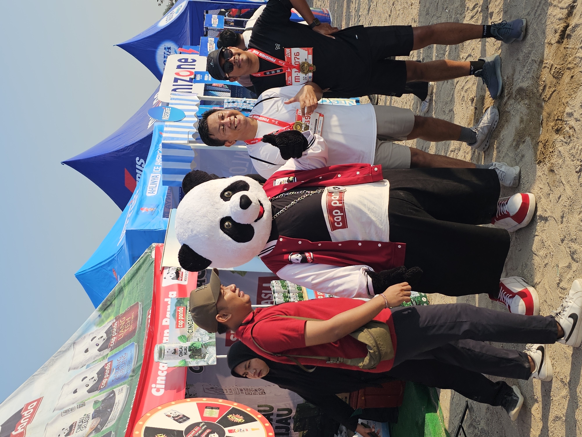 Post-race gathering in Denpasar with BCA branding and a panda mascot