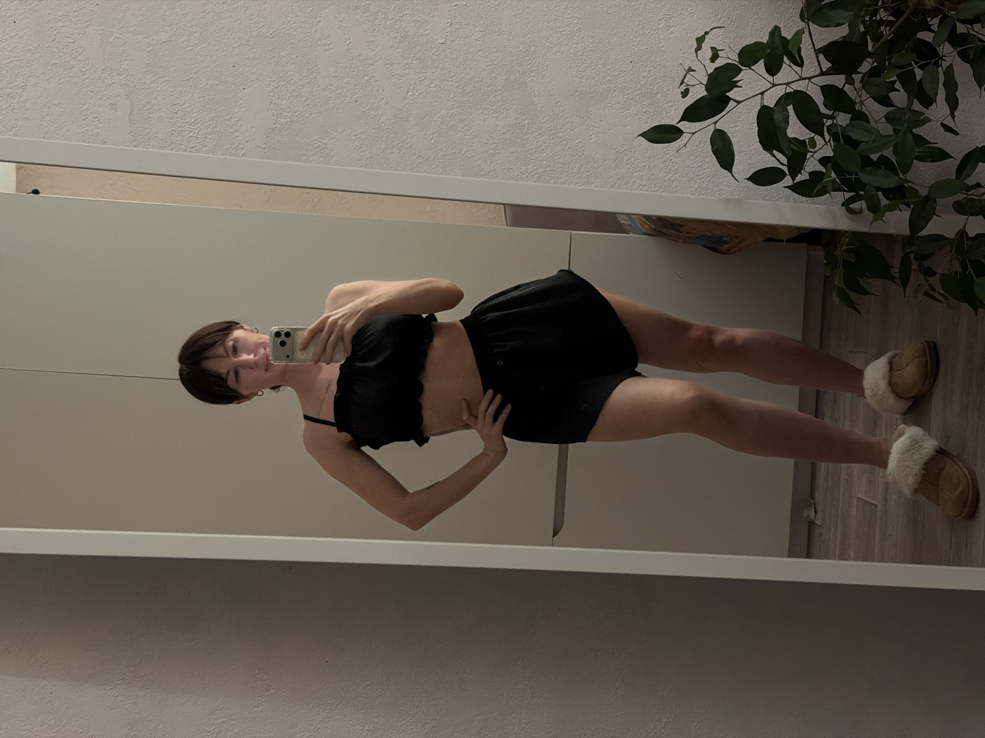 Woman takes mirror selfies in black outfit, Perm apartment
