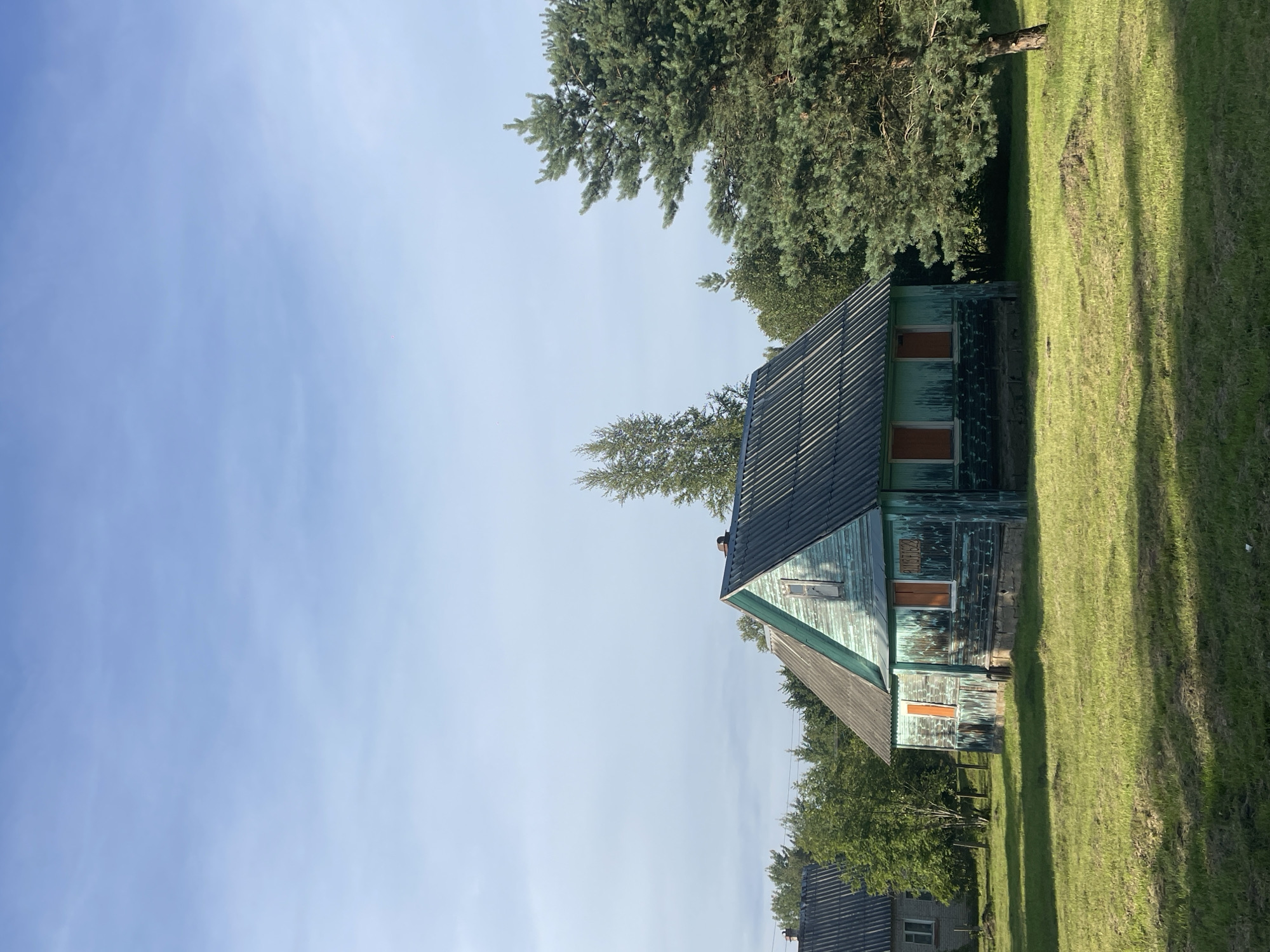 Weathered teal wooden house in a Kobona field