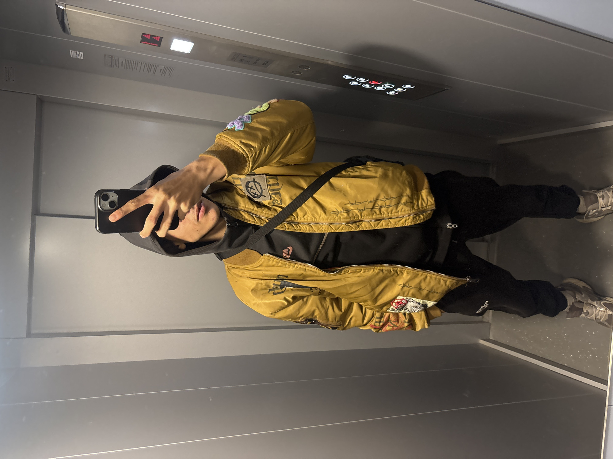Person takes elevator selfie in yellow jacket, Shumen