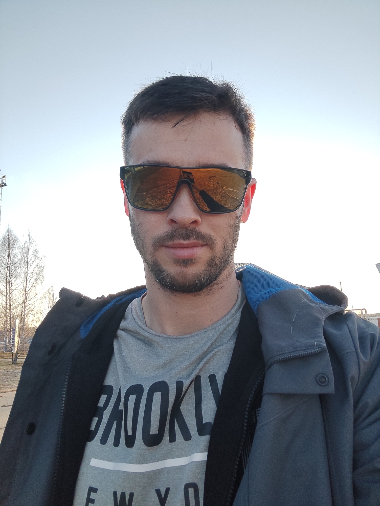 Man captures outdoor selfie wearing reflective orange sunglasses