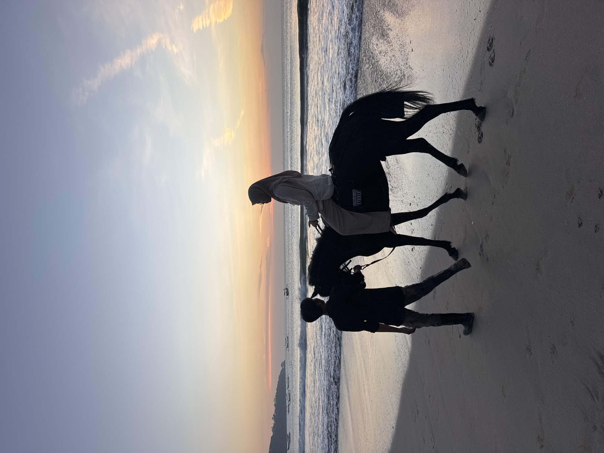Sunset beach dinner event, horses, and evening crowds at Kuta