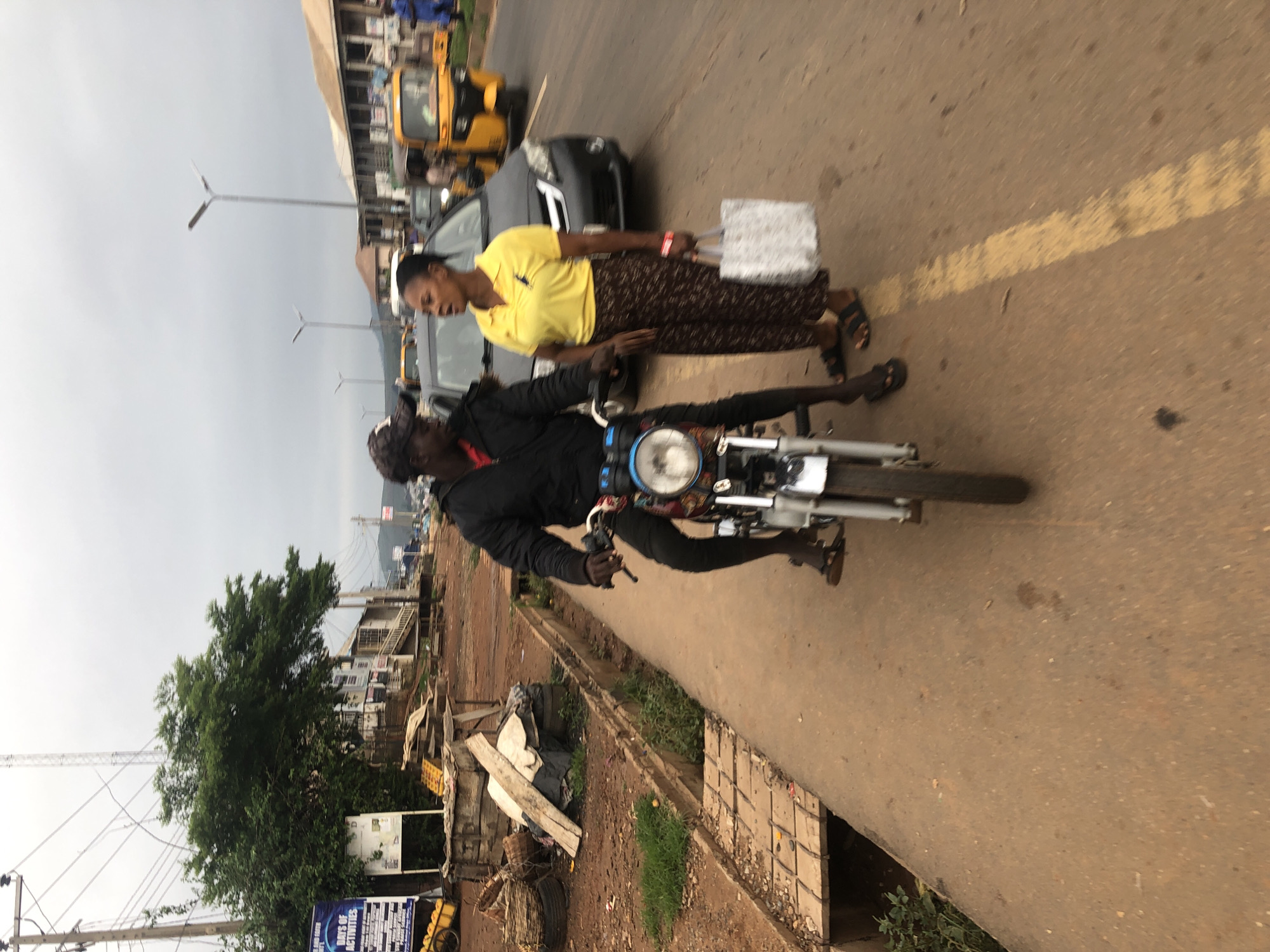 Morning traffic scene observed in Abuja with motorcyclist, pedestrian
