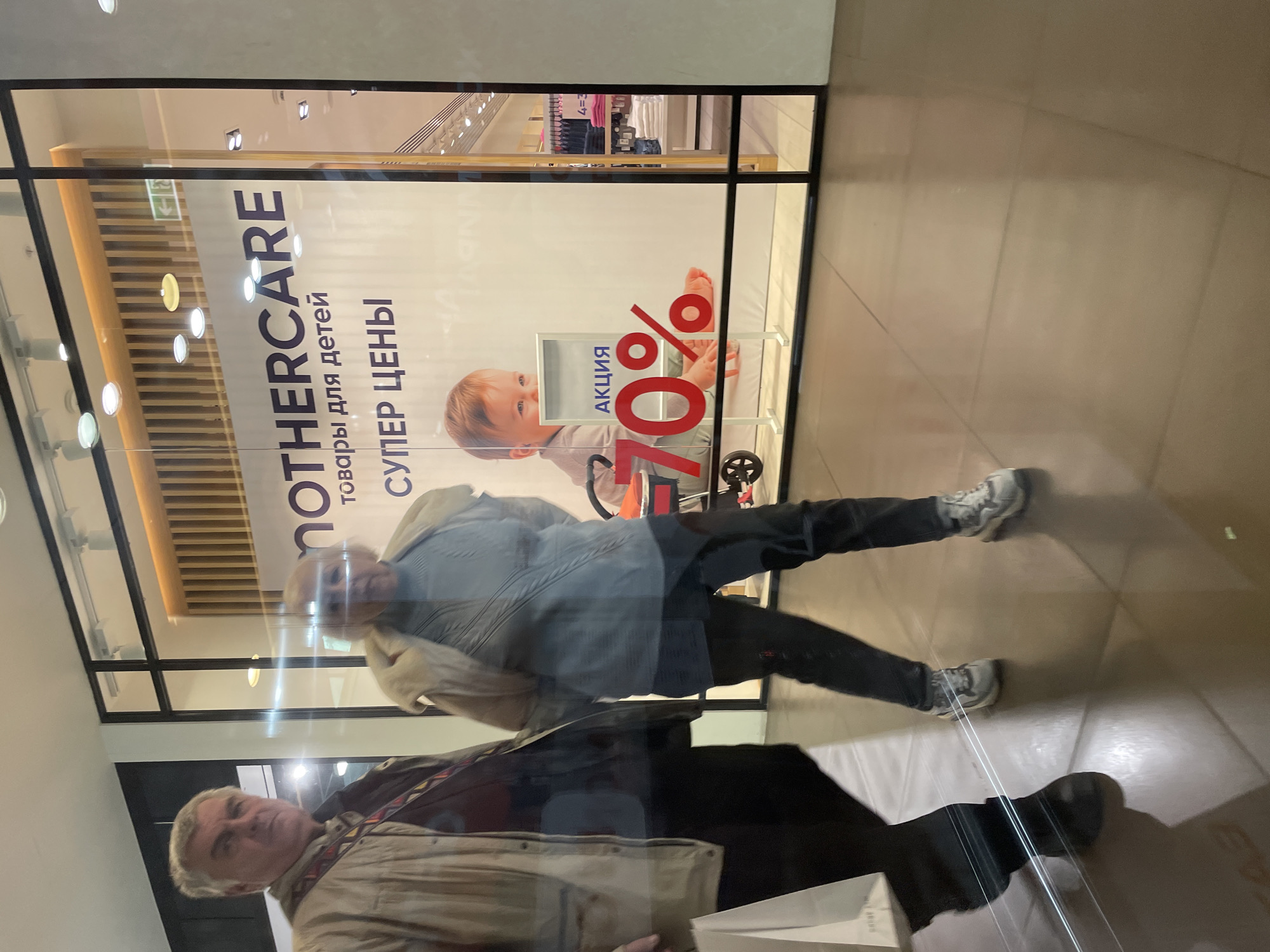 Shoppers reflected in Mothercare window in Saint Petersburg