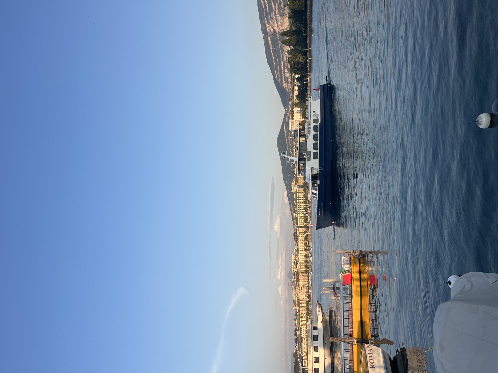 Geneva lakefront at dusk: boats, the Brunswick Monument, and street scenes.