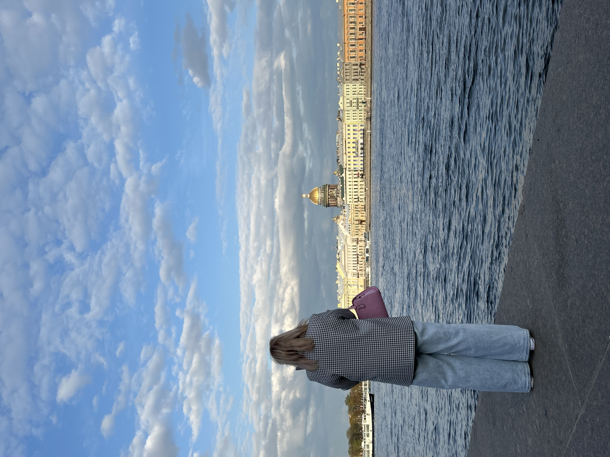 Woman observed standing on Neva River embankment in Saint Petersburg