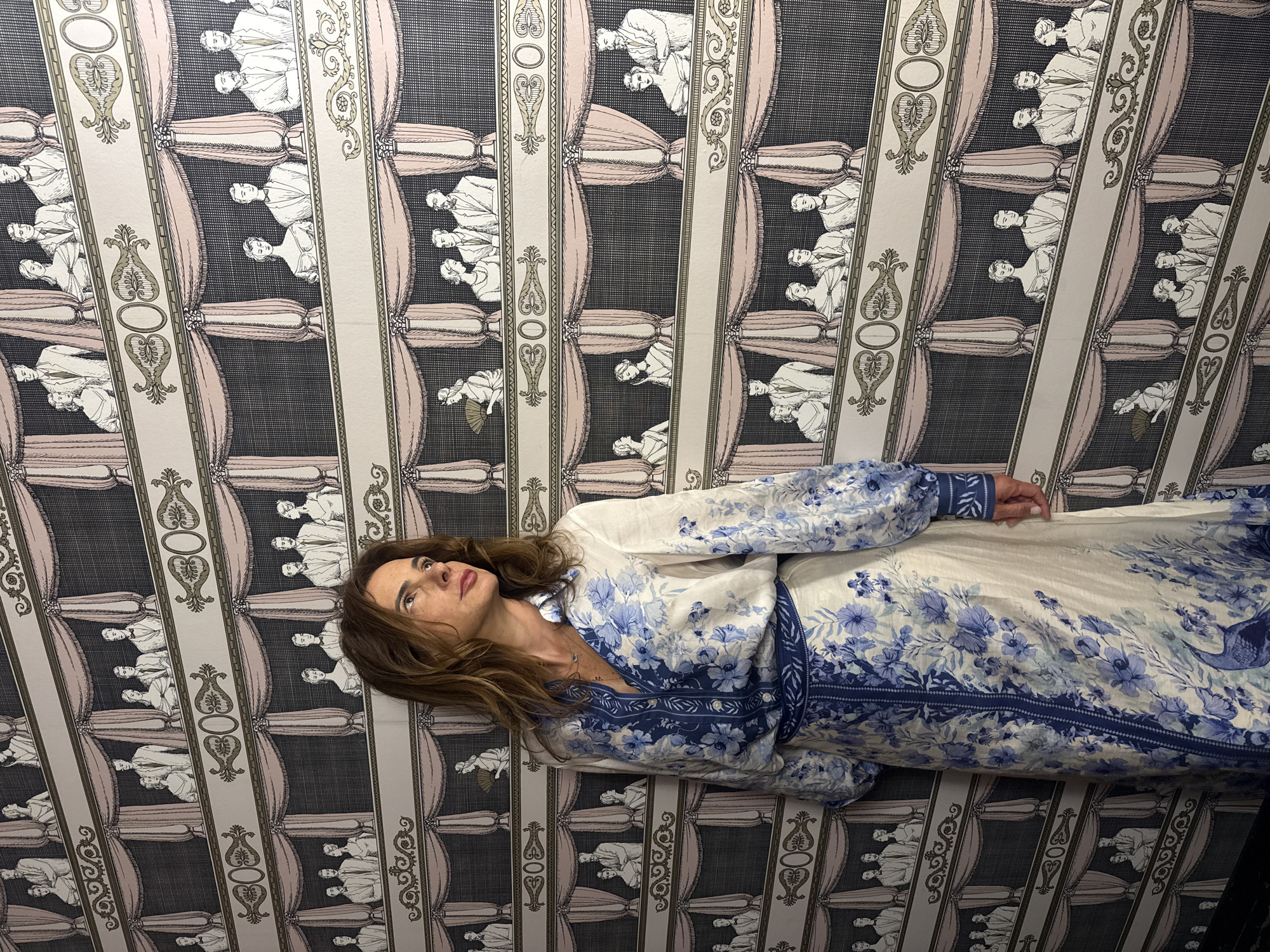 Two women take selfies in patterned room in Vila Verde