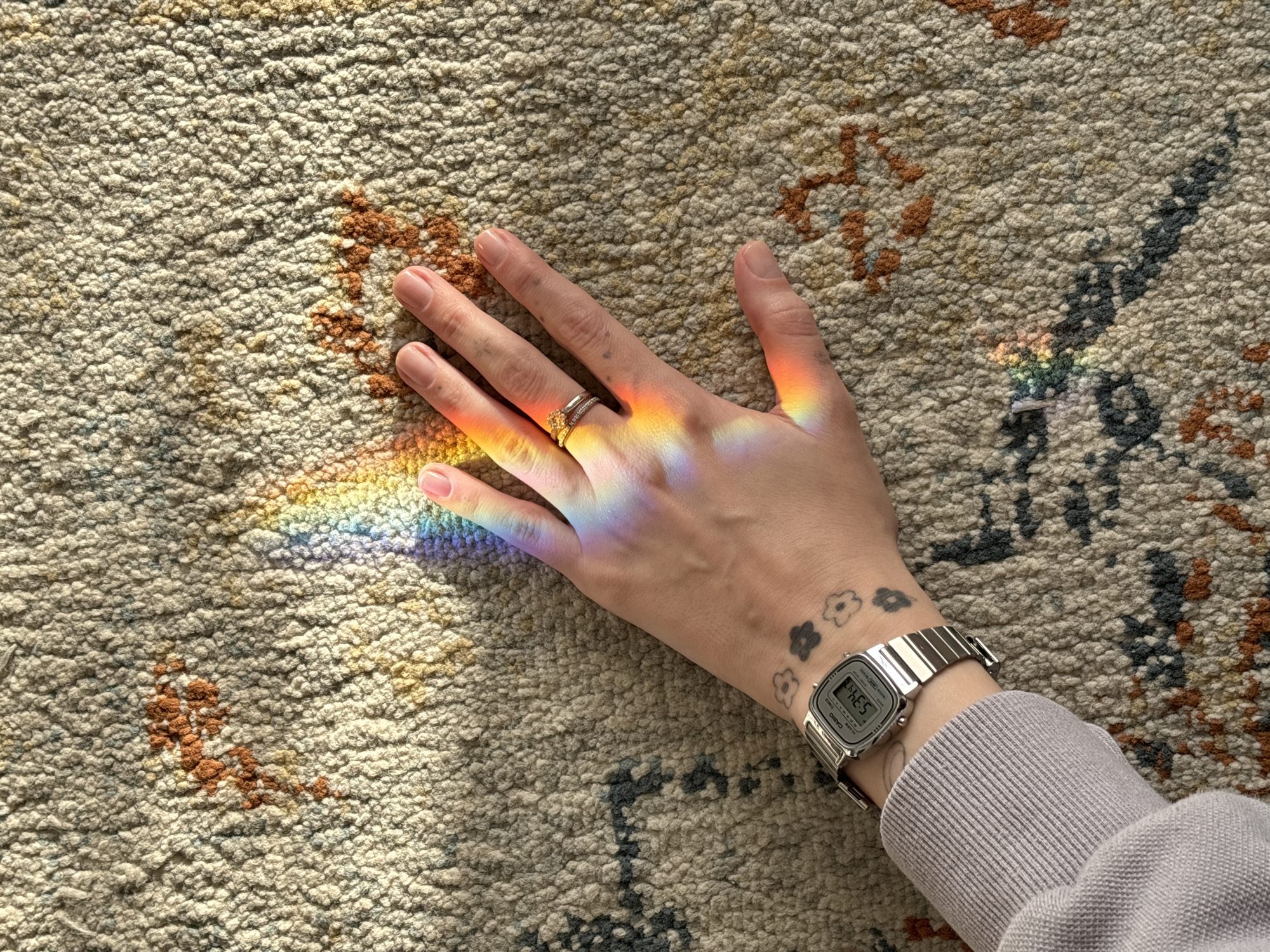 Rainbow light prism cast across hand in Bat Yam home