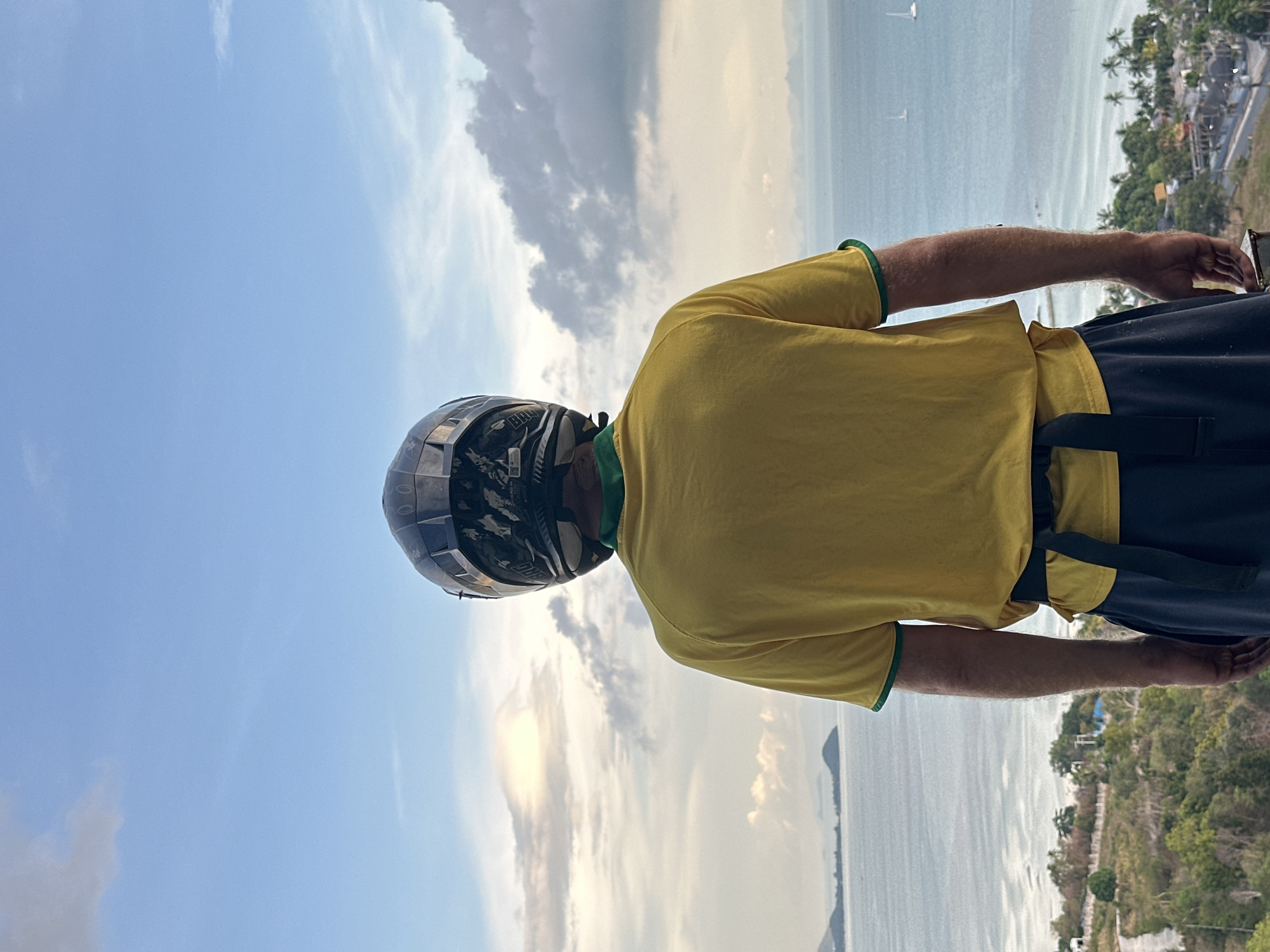 Motorcyclist pauses for ocean view in Nathon, Thailand