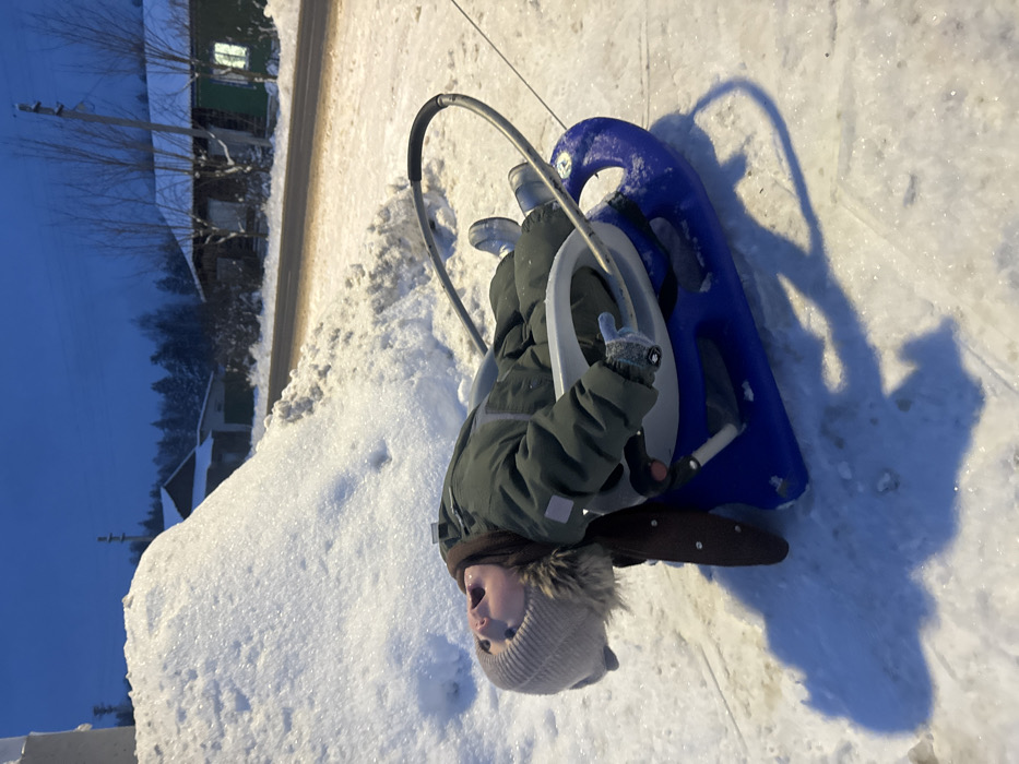 Child sleds on snowy street in Красный Маяк