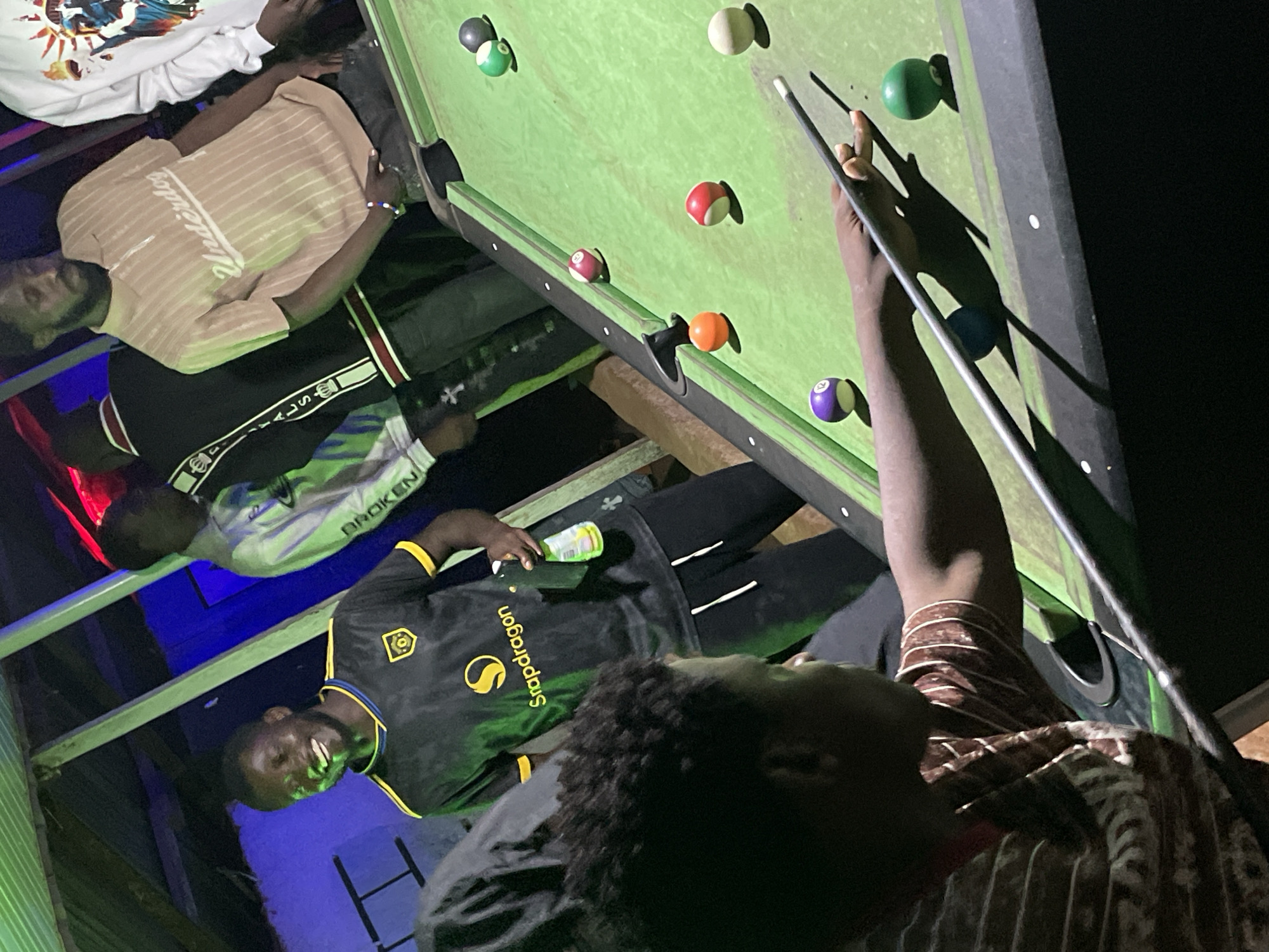 Late-night pool hall scene in Wumat, Nigeria