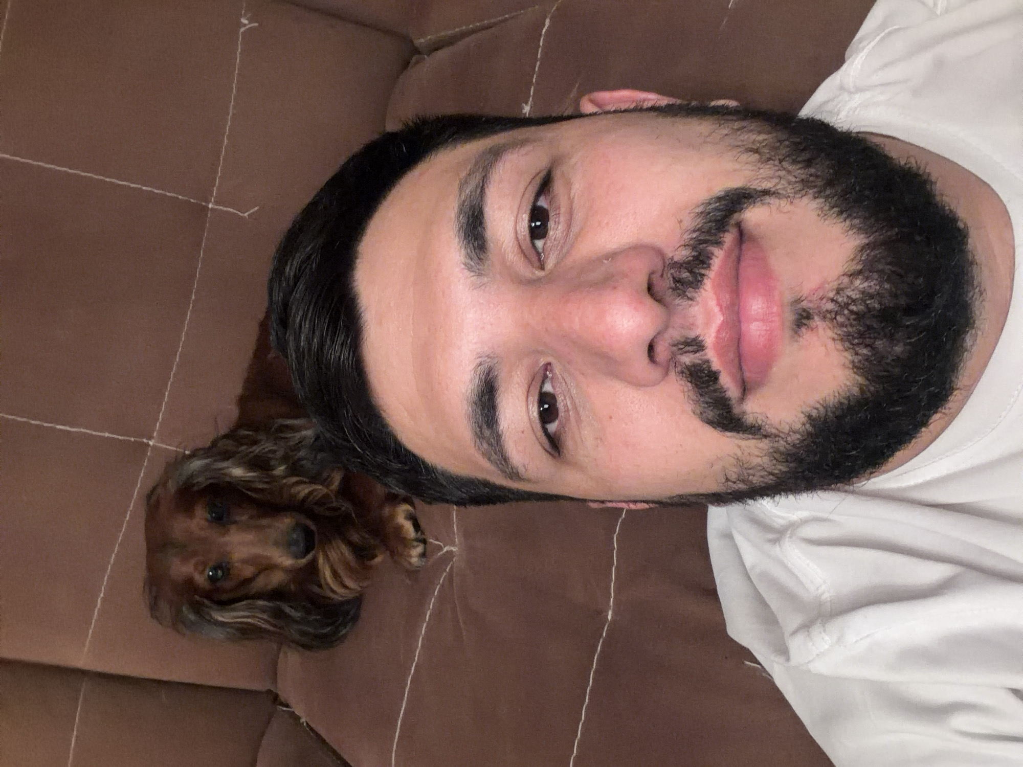 Man and dachshund share affectionate couch time in Krasnoyarsk