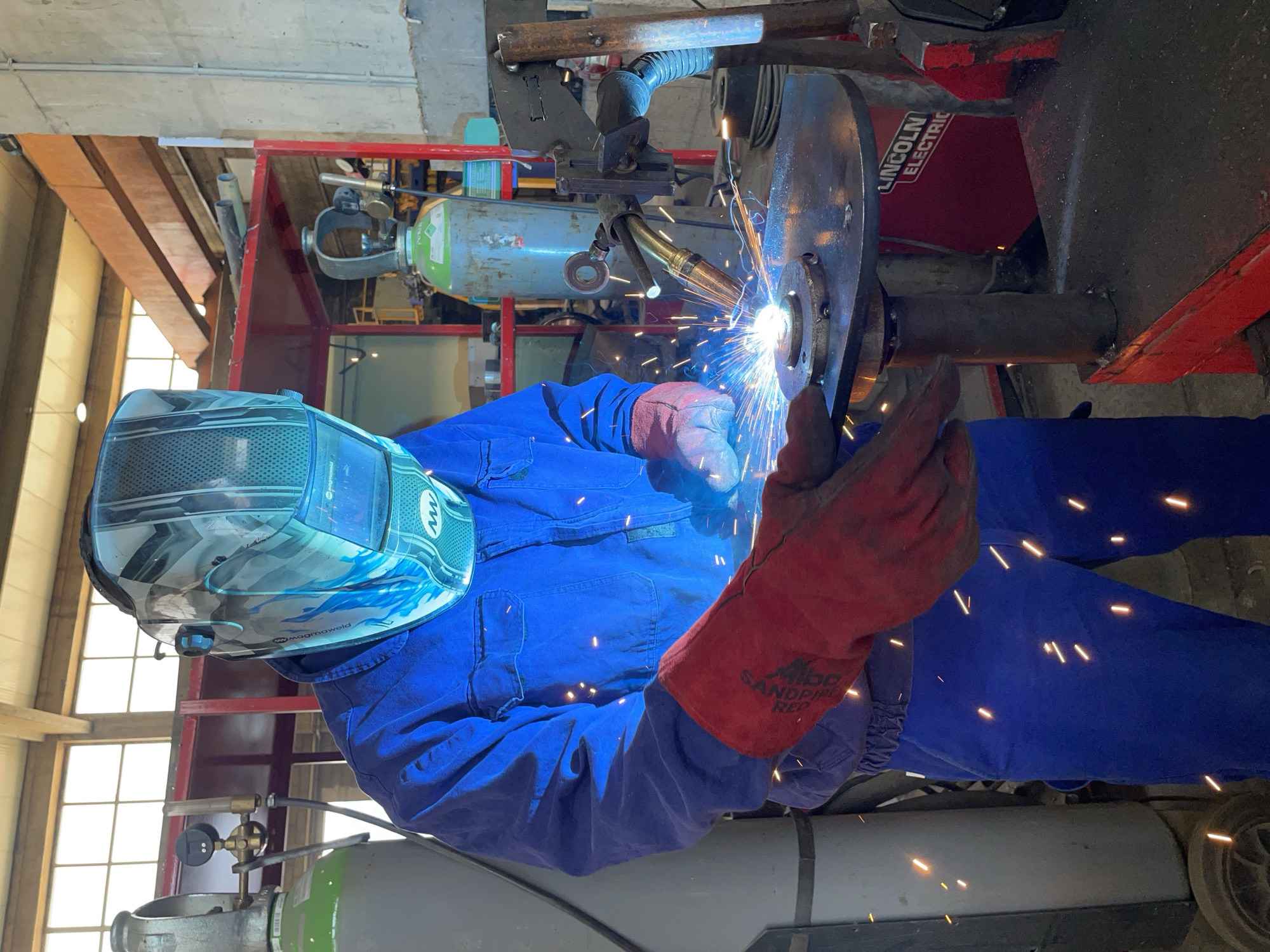 Welder at work in a Montenegrin workshop, sparks flying