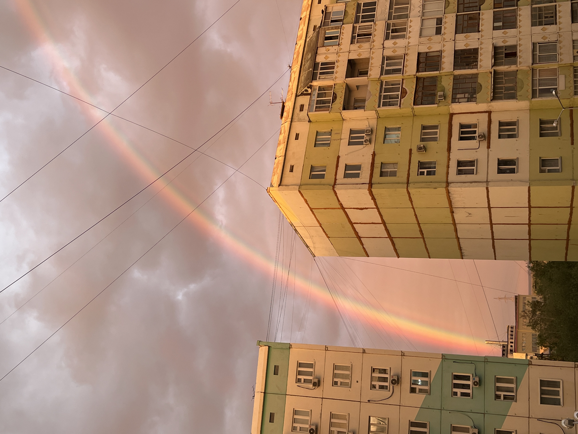 Rainbow and sunset light over Yakutsk apartment blocks