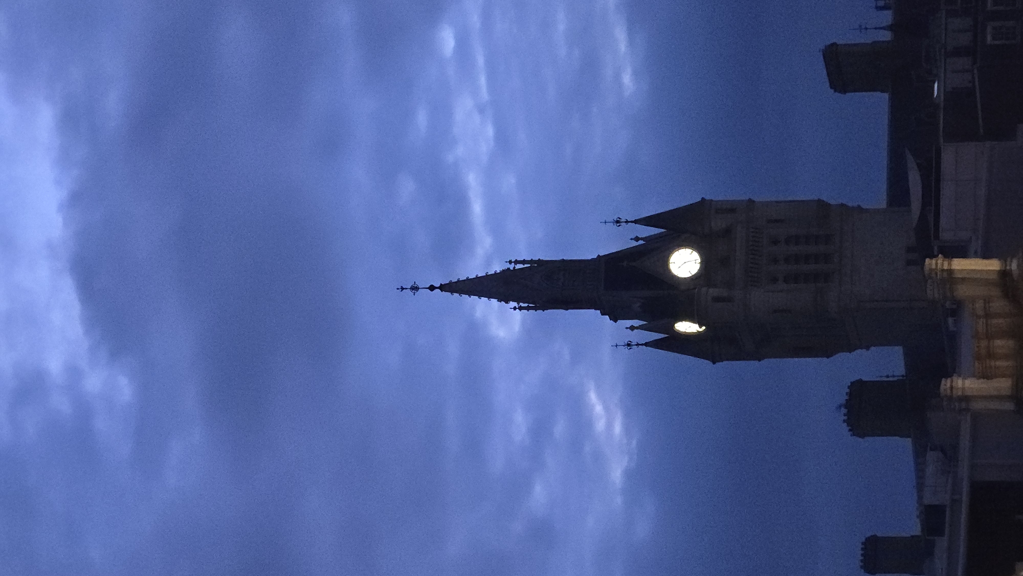 Gothic clock tower stands against Aberdeen's cloudy night sky